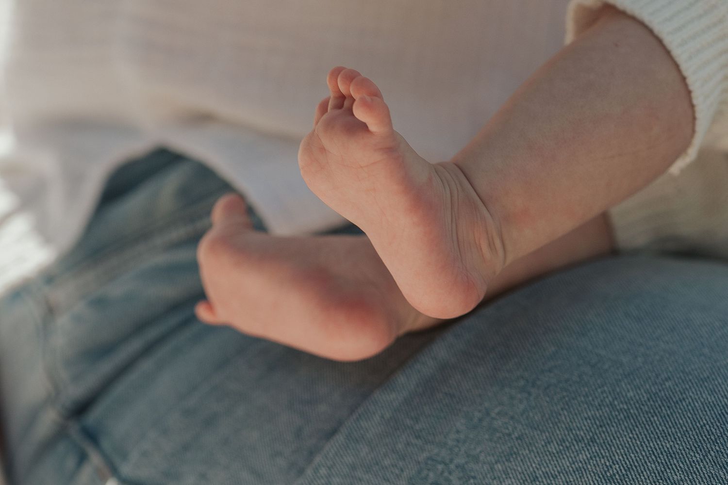 Series of tiny baby feet resting on a blue blanket.