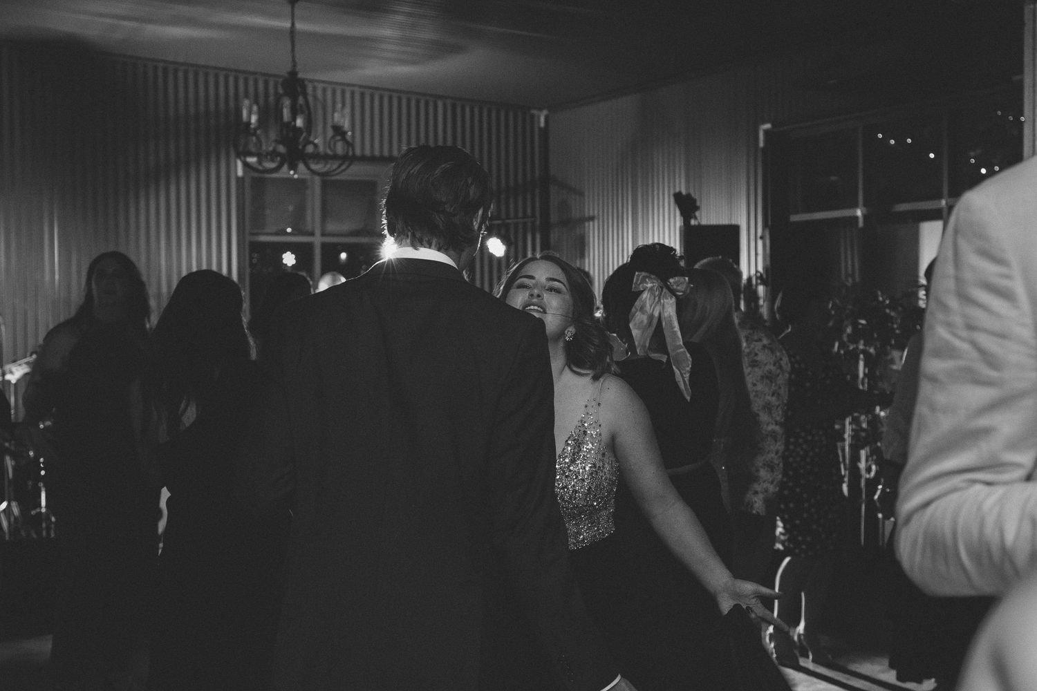 Dimly lit venue with guests mingling and socializing during evening celebration.