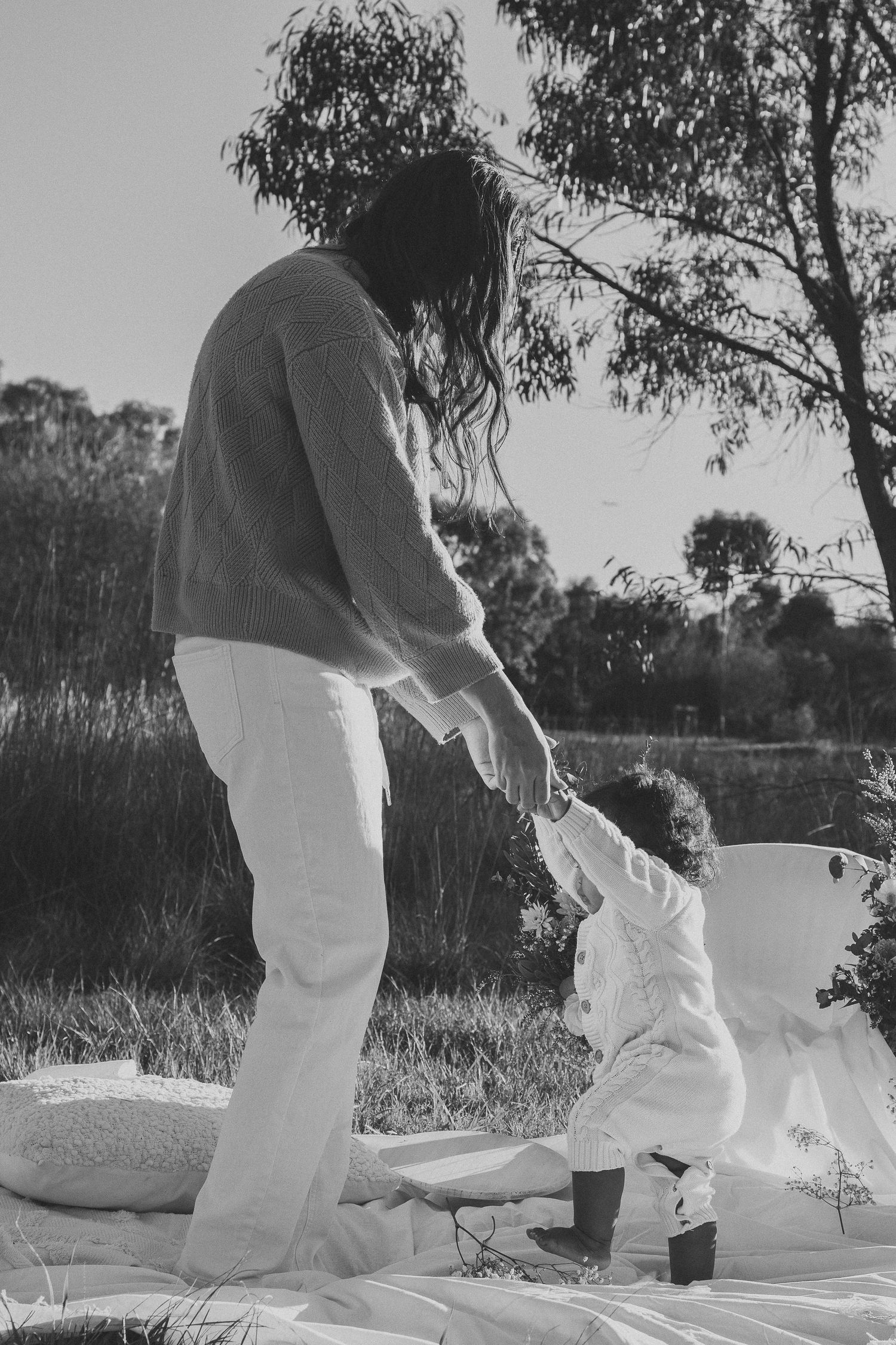 Black and white sequence showing someone in white clothing moving gracefully in an outdoor setting.