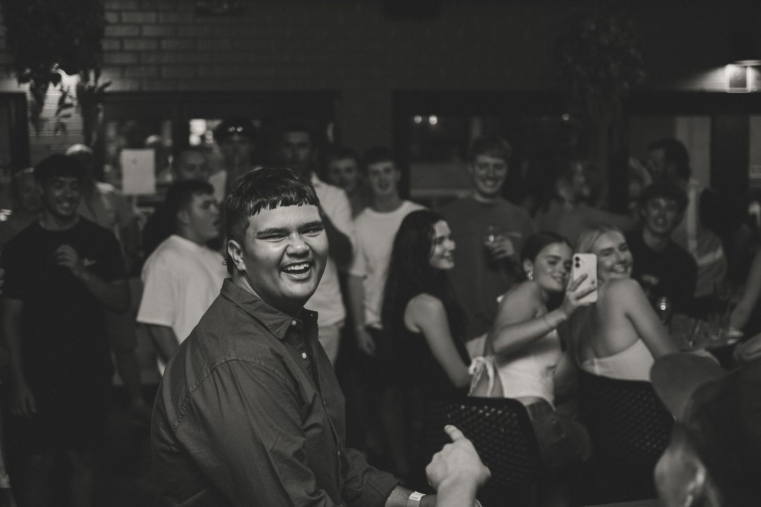 Black and white photo of lively indoor party scene.