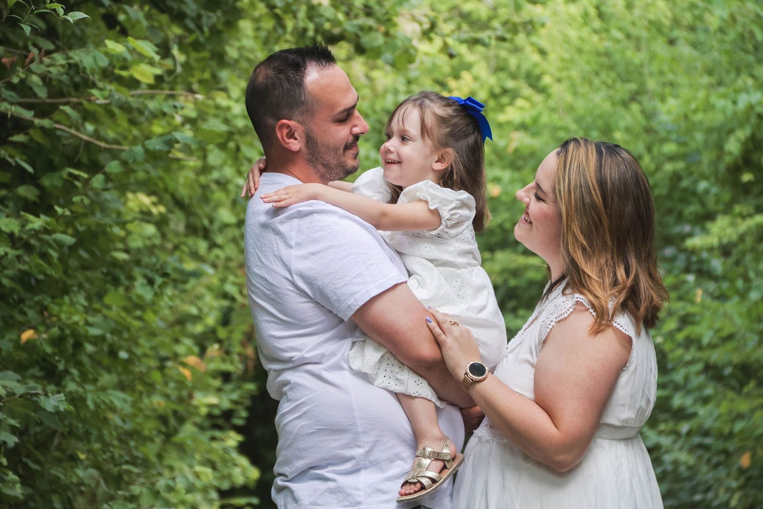 Séance famille lifestyle — parents enlacés avec leur bébé, moment tendre capté en lumière naturelle, photographe Reims Marne.