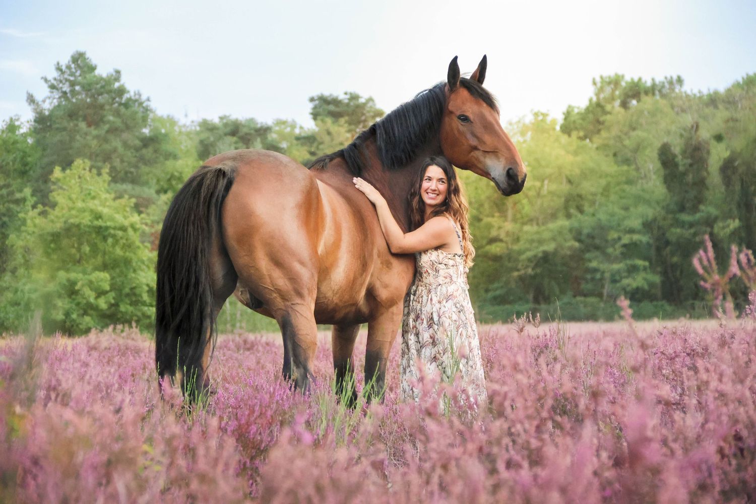 Séance lifestyle — jeune femme en robe fleurie face à son cheval brun dans les bruyères, photographe Aisne Guignicourt.