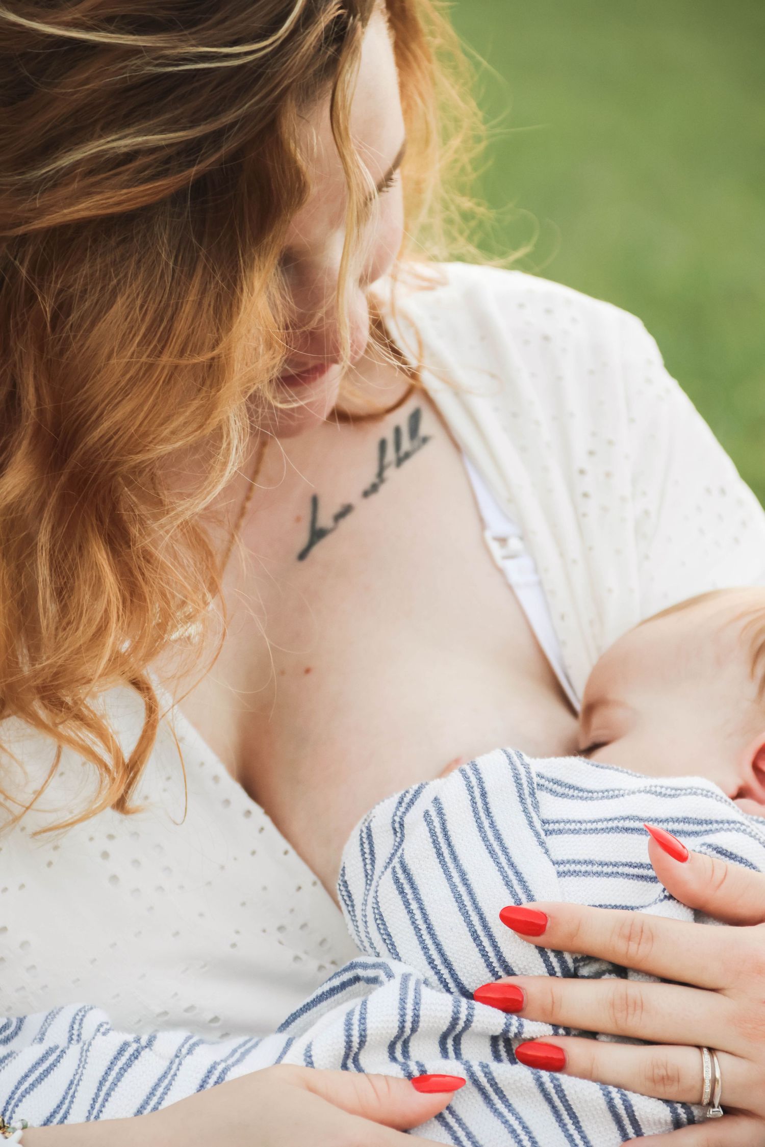 Séance charge mentale — gros plan maman rousse tatouée allaitant son nouveau-né emmailloté, photographe famille Aisne Guignicourt.