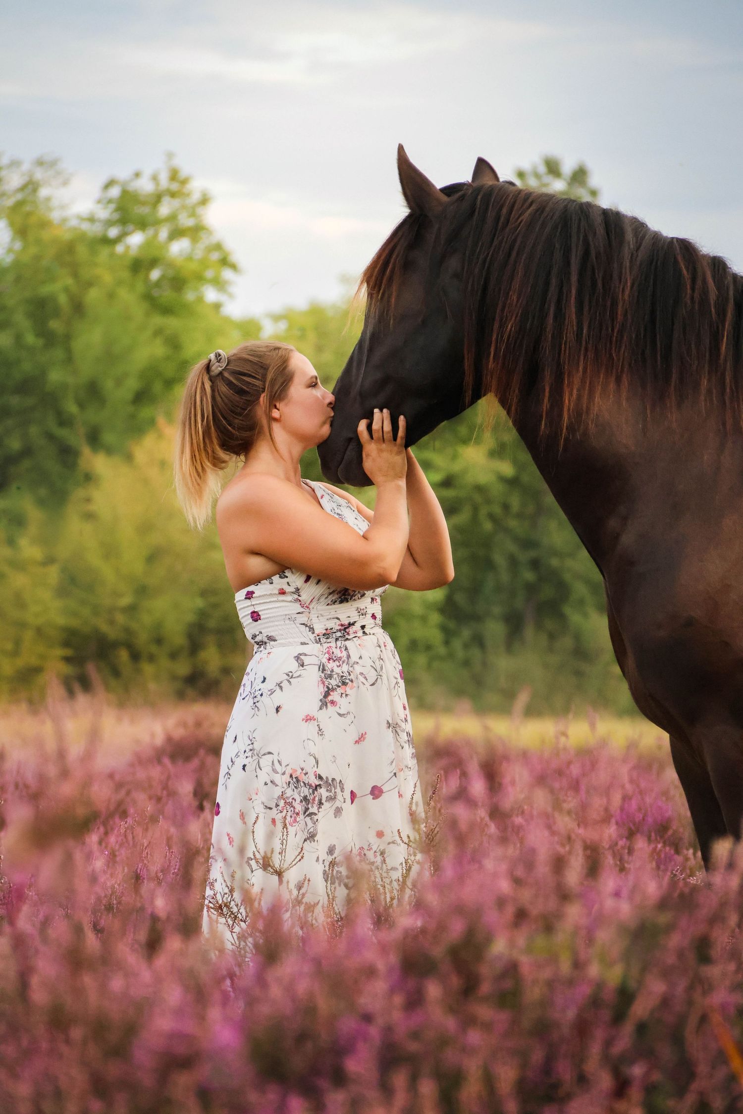Séance lifestyle — jeune femme en robe fleurie face à son cheval brun dans les bruyères, photographe Aisne Guignicourt.