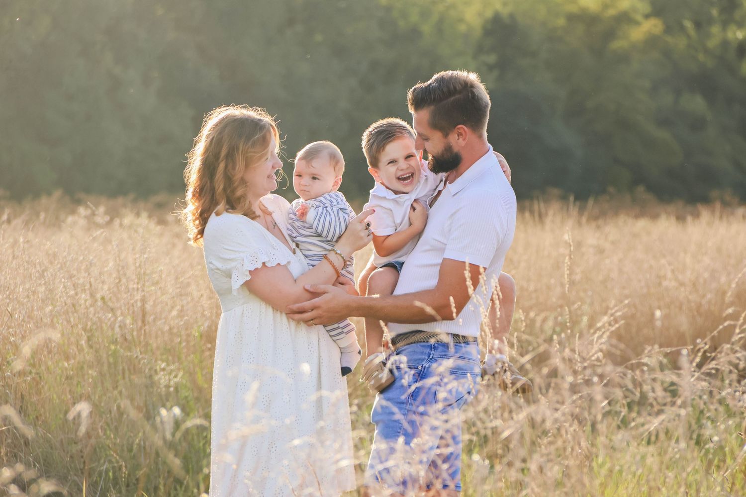 Séance famille lifestyle — famille heureuse avec deux jeunes enfants profitant d'une journée ensoleillée dans un champ doré, photographe Ais