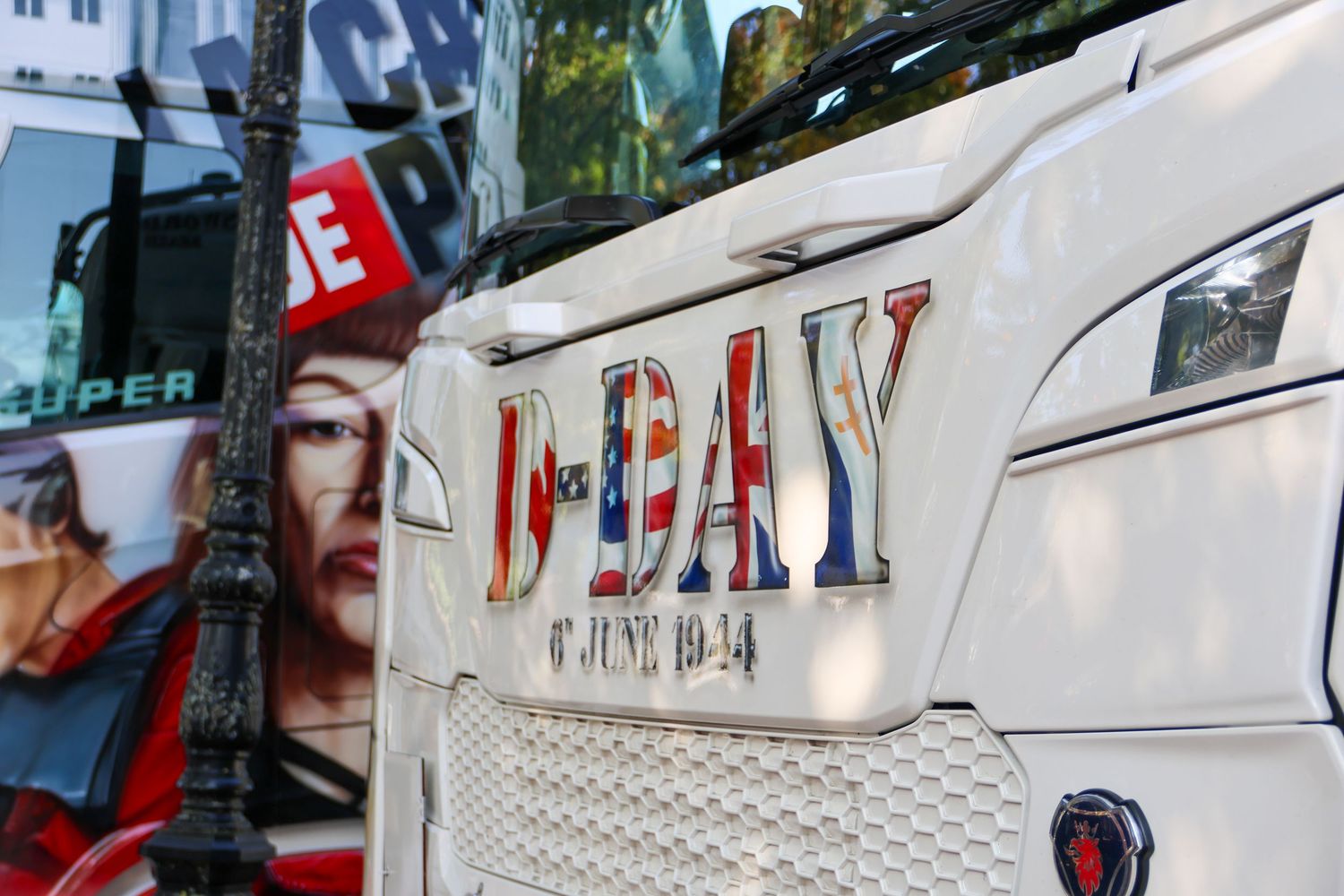 Close-up of a white truck cab displaying D-Day 6 June 1944 commemorative text with American flag design.