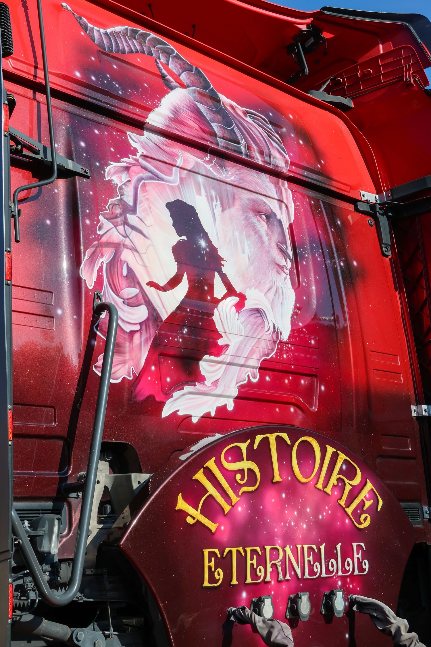 Red truck with fantasy airbrush art featuring a silhouette and dragon, labeled Histoire Eternelle.