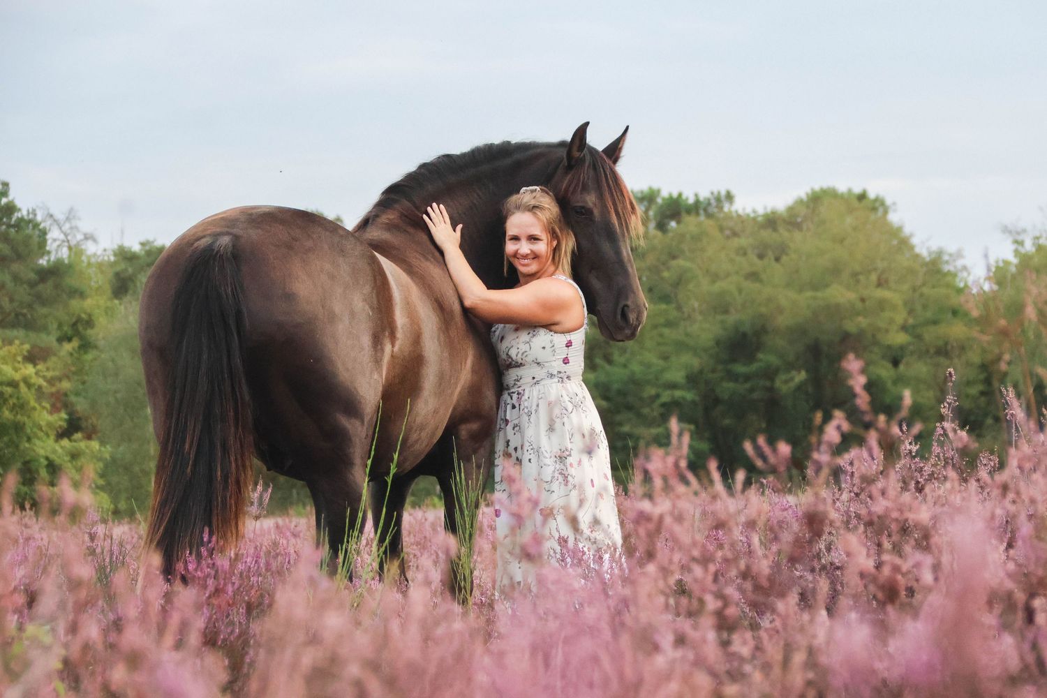Séance lifestyle — jeune femme en robe fleurie face à son cheval brun dans les bruyères, photographe Aisne Guignicourt.
