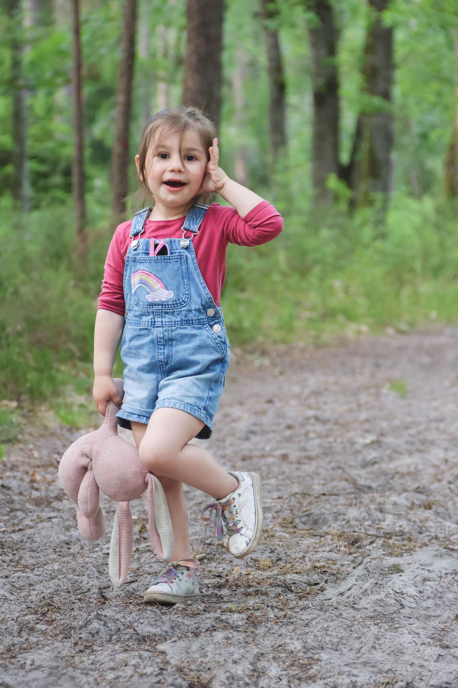 Séance famille lifestyle — petite fille en salopette jean tenant un lapin rose sur un chemin forestier, photographe Charleville-Mézières
