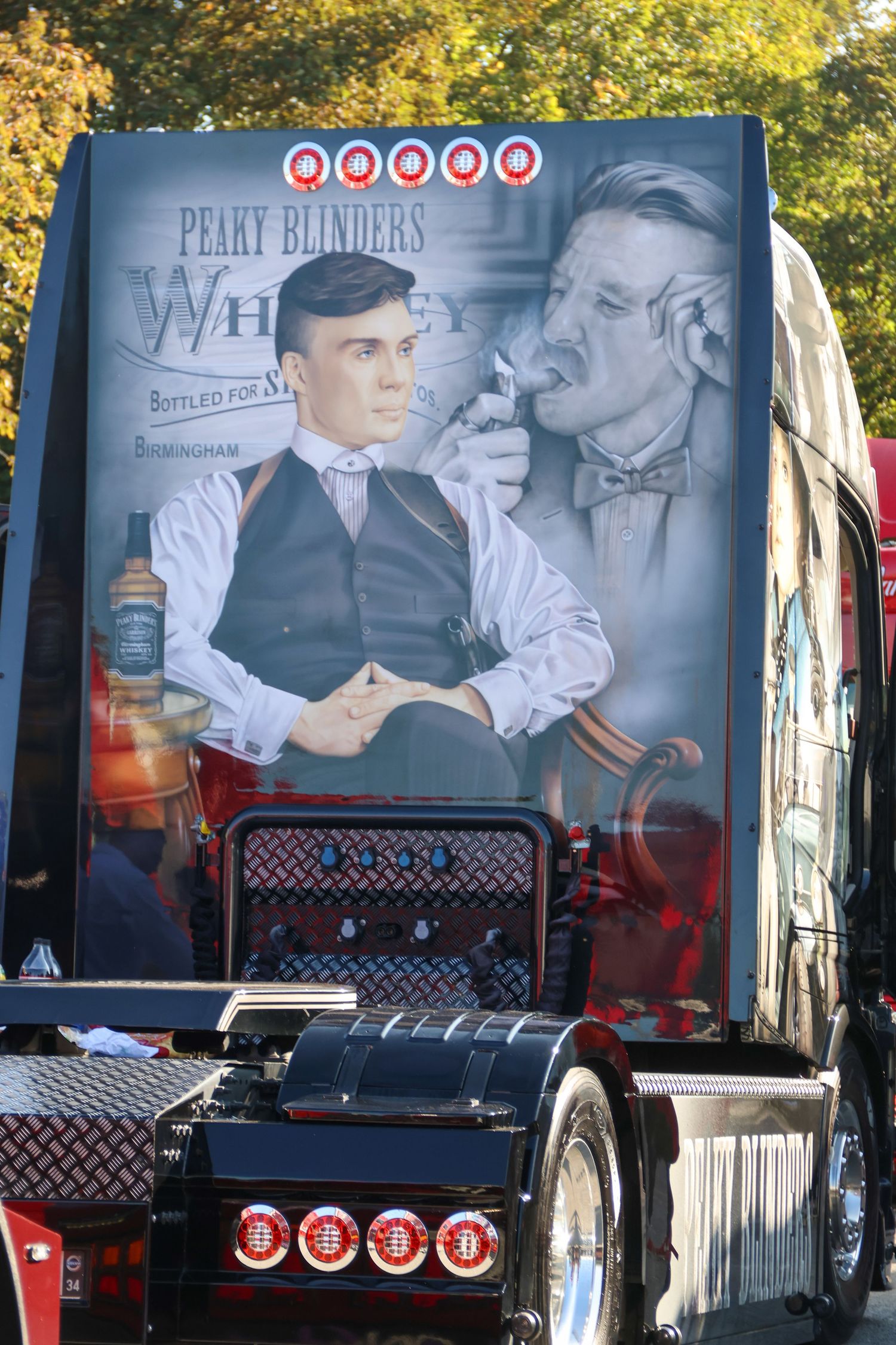 Custom truck rear featuring Peaky Blinders Whiskey airbrushed artwork with suited men and whiskey bottle.