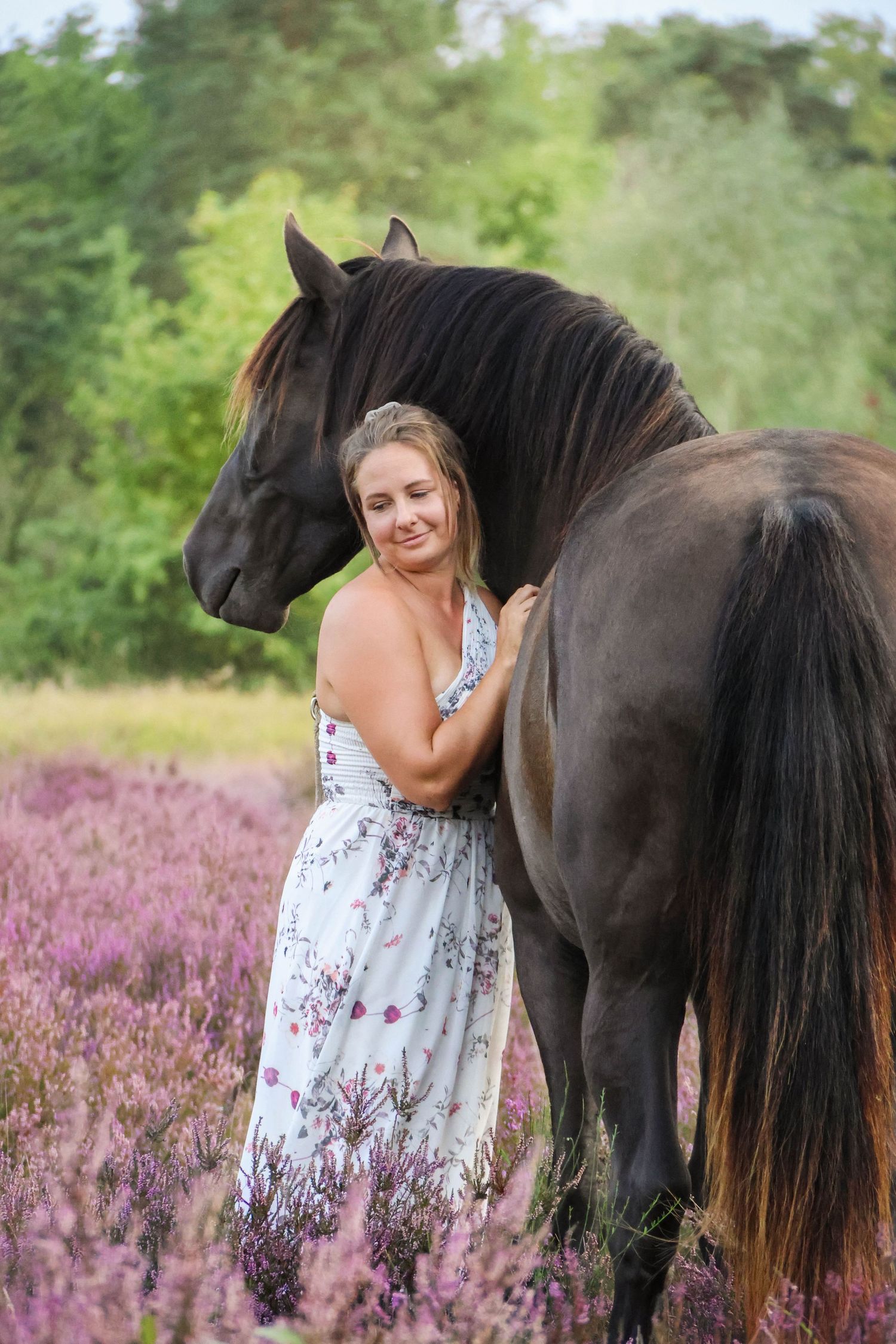 Séance lifestyle — jeune femme en robe fleurie face à son cheval brun dans les bruyères, photographe Aisne Guignicourt.