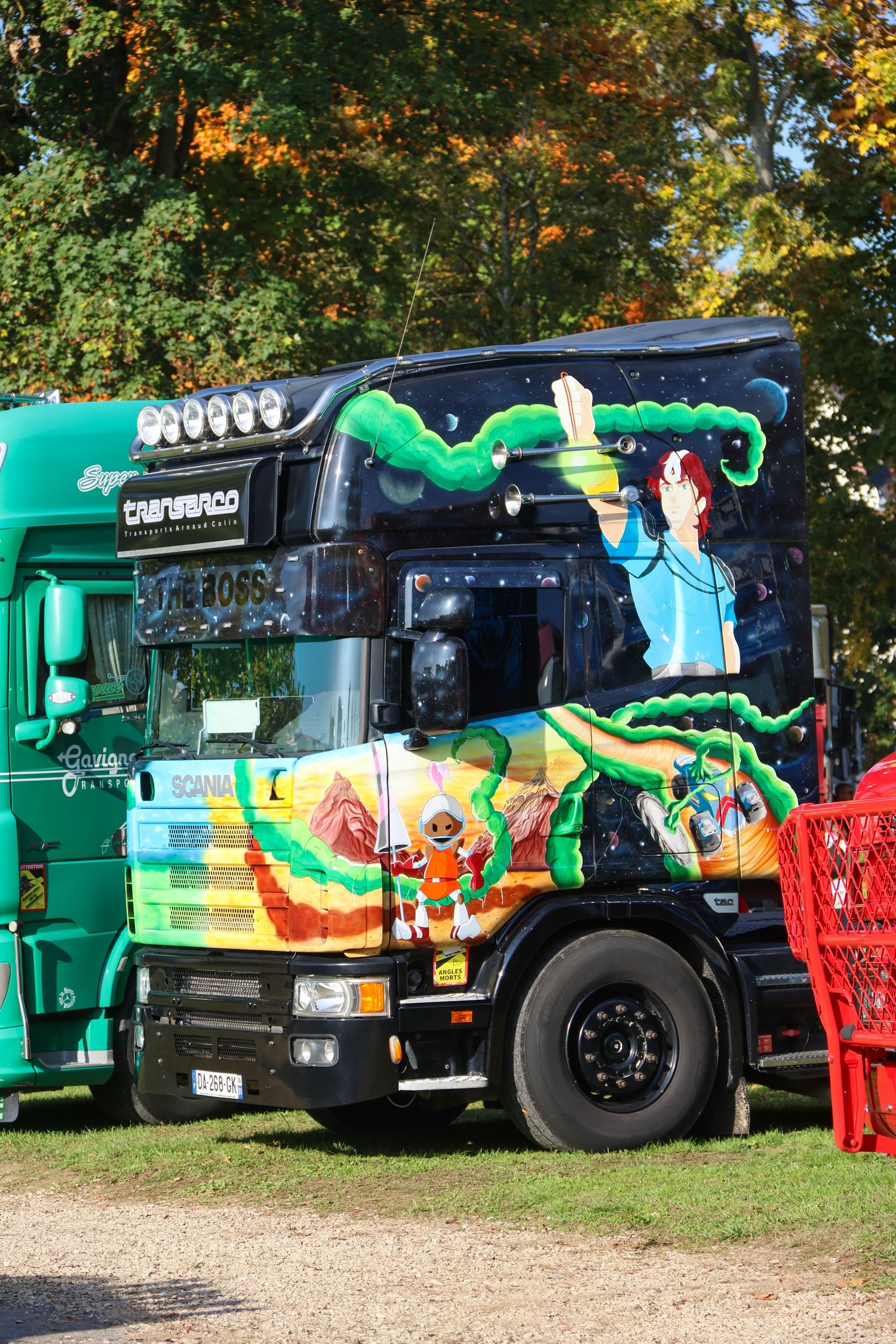 Custom Scania truck featuring vibrant anime-style airbrush artwork with green tentacles and characters.