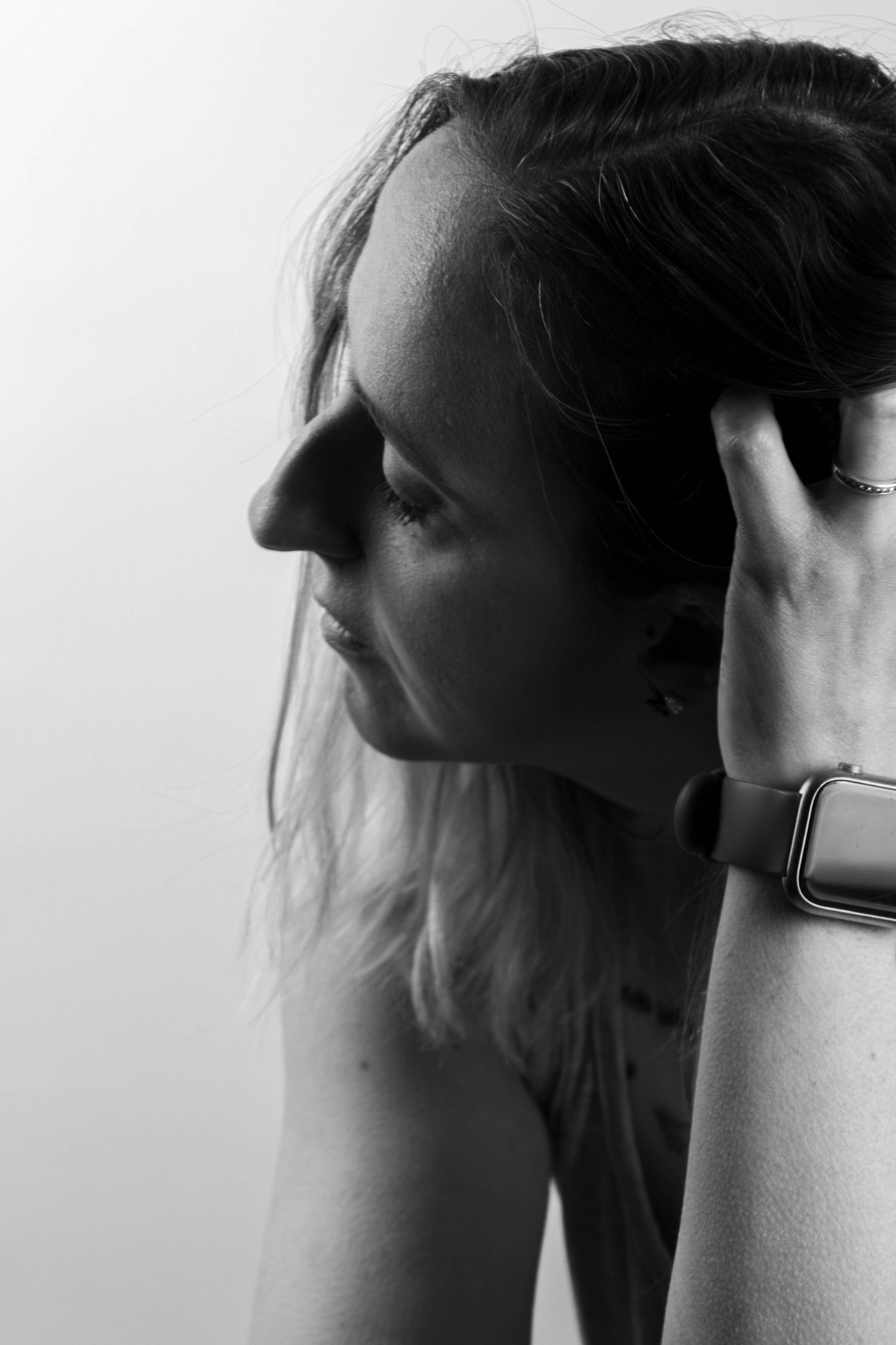 Séance Harmonie — portrait studio noir et blanc femme tatouée retenant ses cheveux en débardeur et bracelets, photographe Rethel Ardennes.