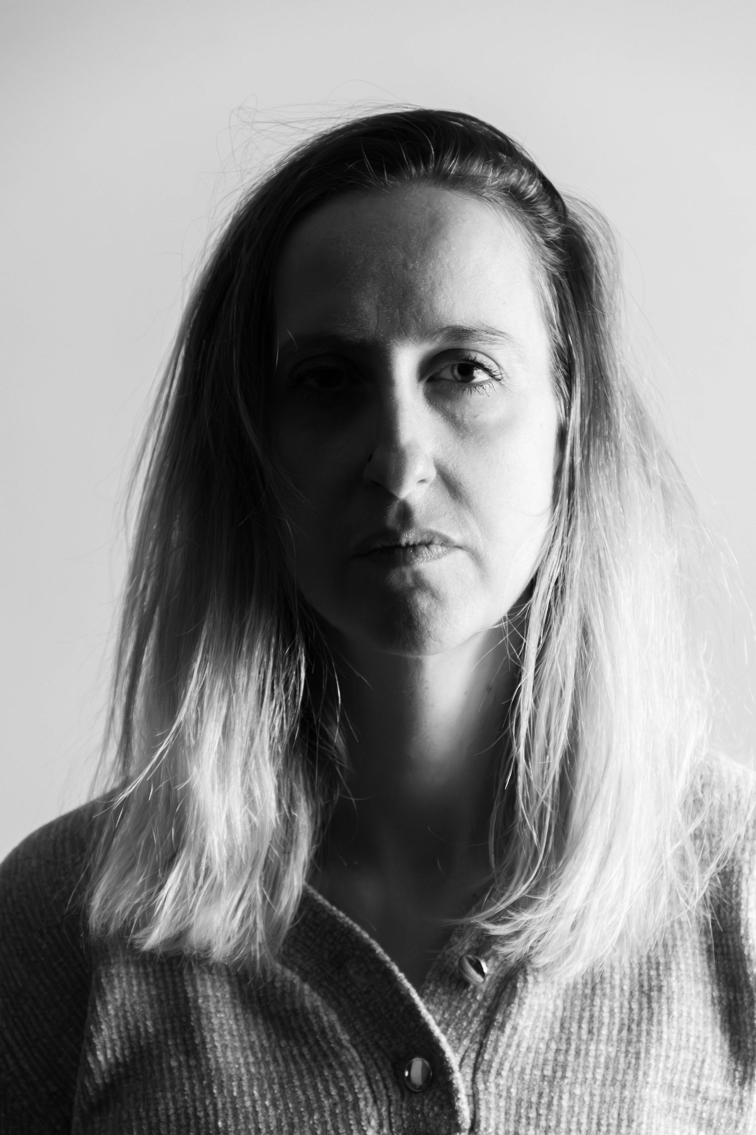 Séance Harmonie — portrait studio noir et blanc dramatique femme aux longs cheveux dans l'ombre en chemise, reconnexion à l'image