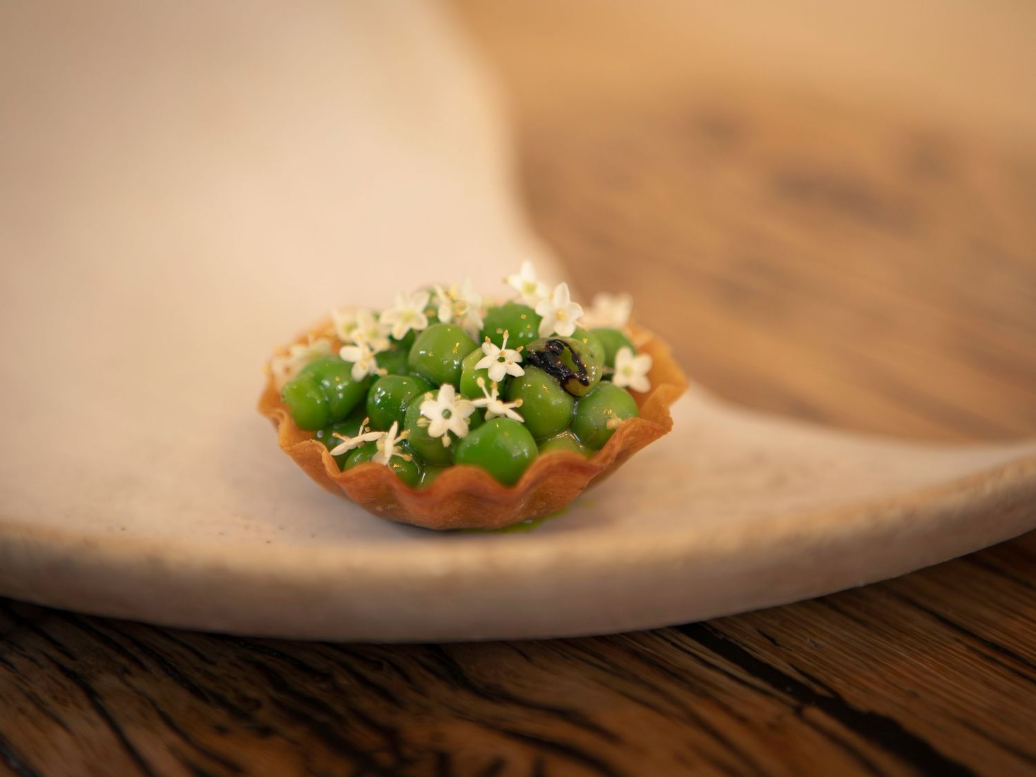 Gros plan d'une tartelette garnie de petits pois