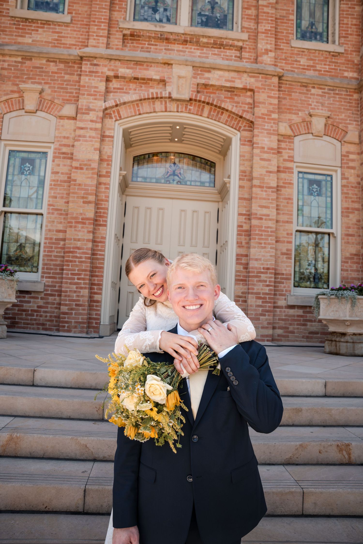 Loving couple shares laughter and joy while posing for wedding photos in front of the Provo City Center LDS temple.