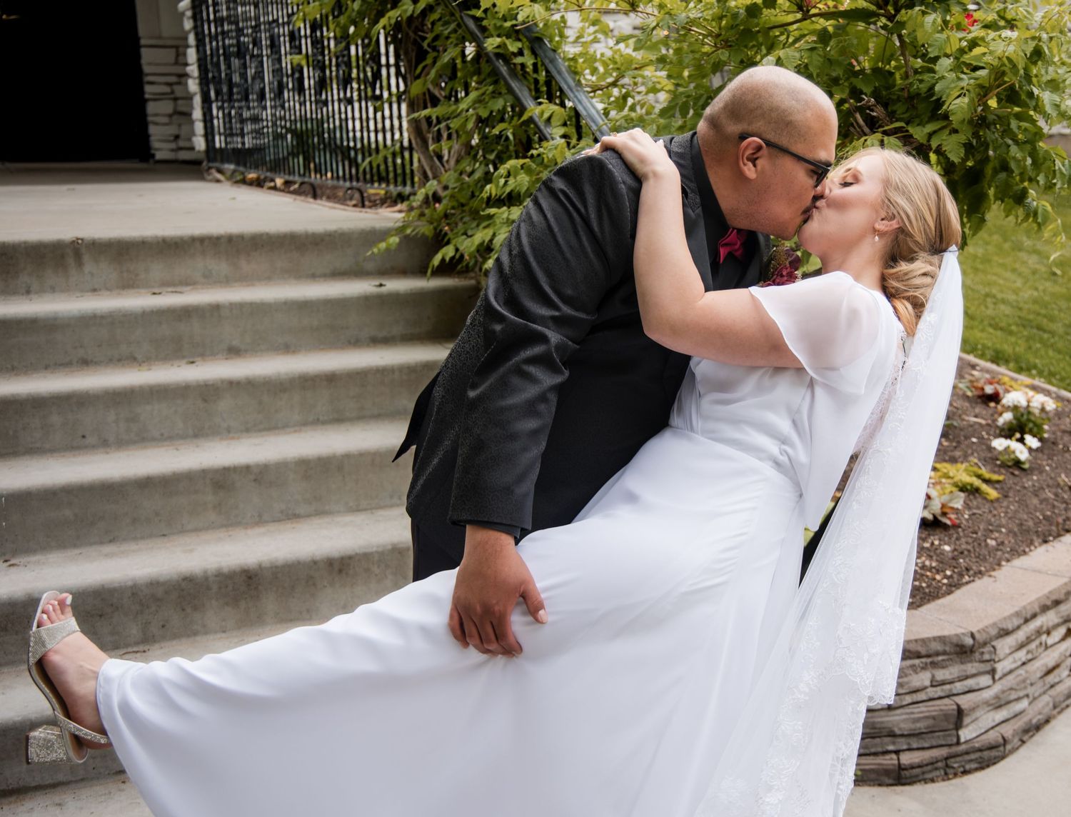 A romantic wedding kiss sequence captured in five progressive frames showing the couple leaning in for the kiss.