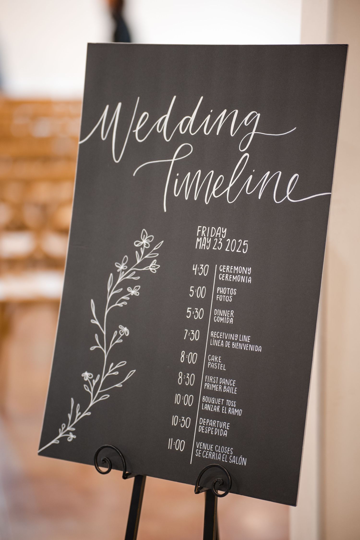 Elegant wedding timeline signs with floral designs displayed on black chalkboards showing event schedules.