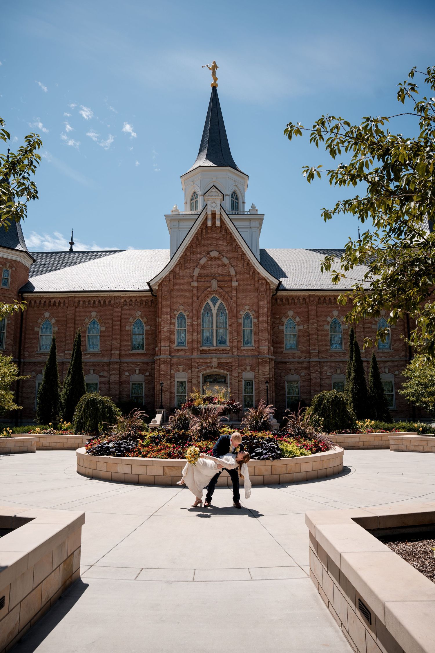 Beautiful Provo City Center LDS Temple with towering spire and intricate landscaping featuring a centered floral garden display.