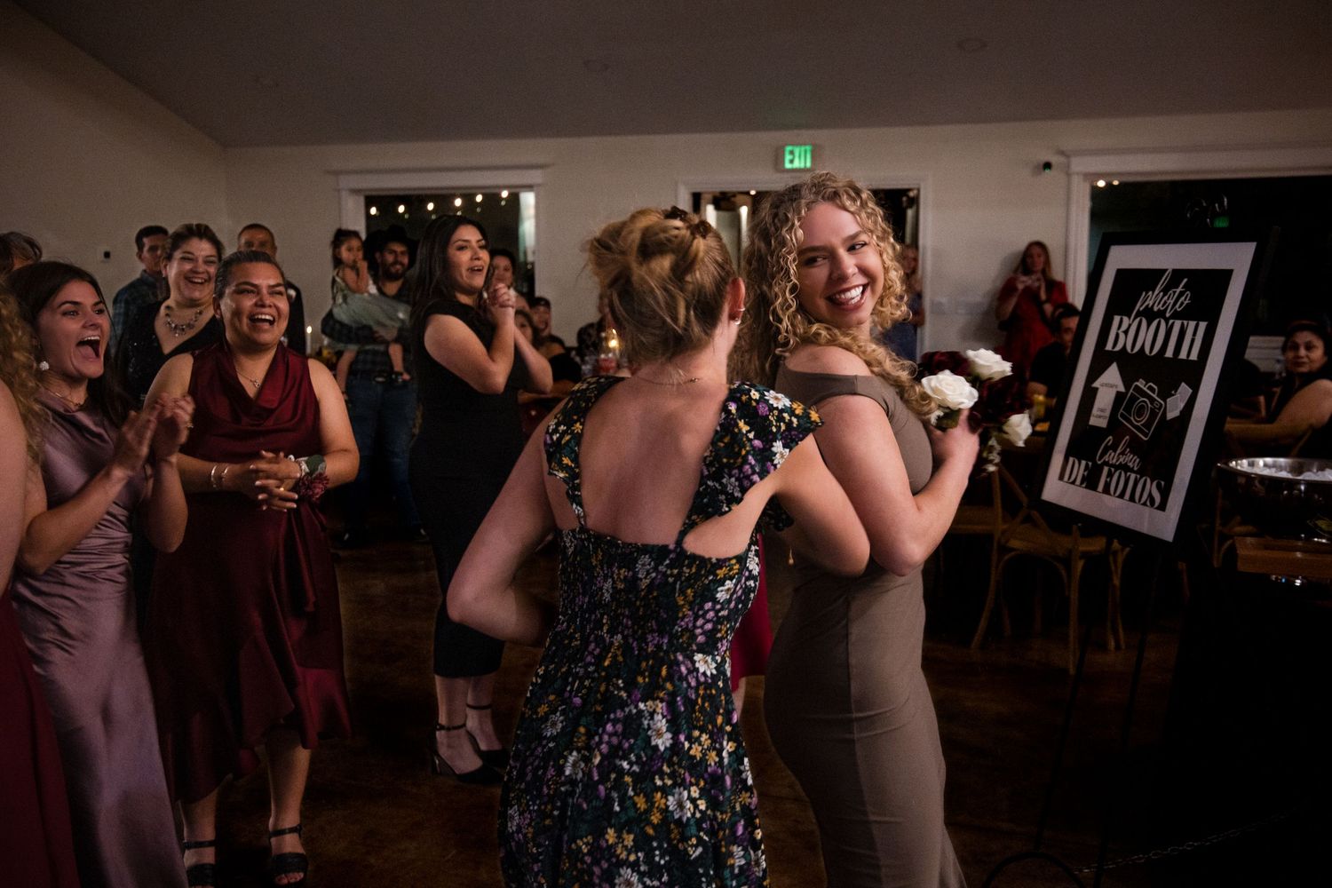 People dancing and socializing at what appears to be a wedding reception or party event.