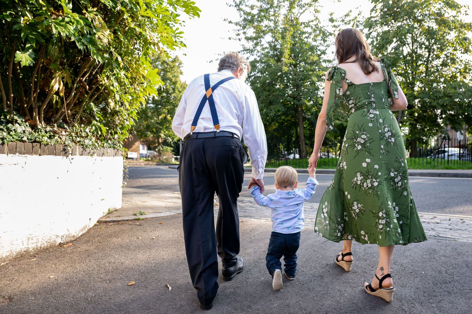 grandfather and mother walking her young son