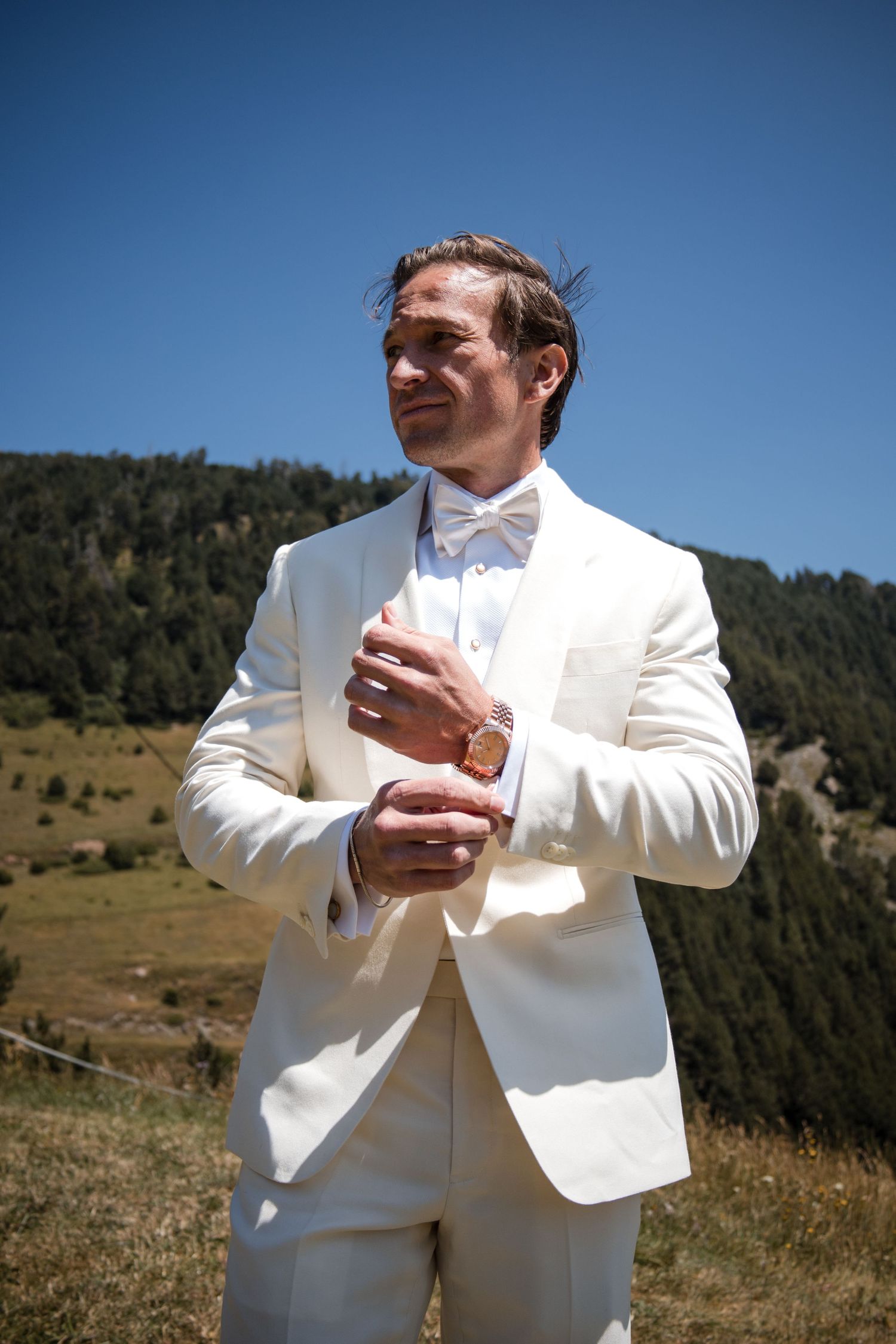 Groom in white, in the mountains in Andorra