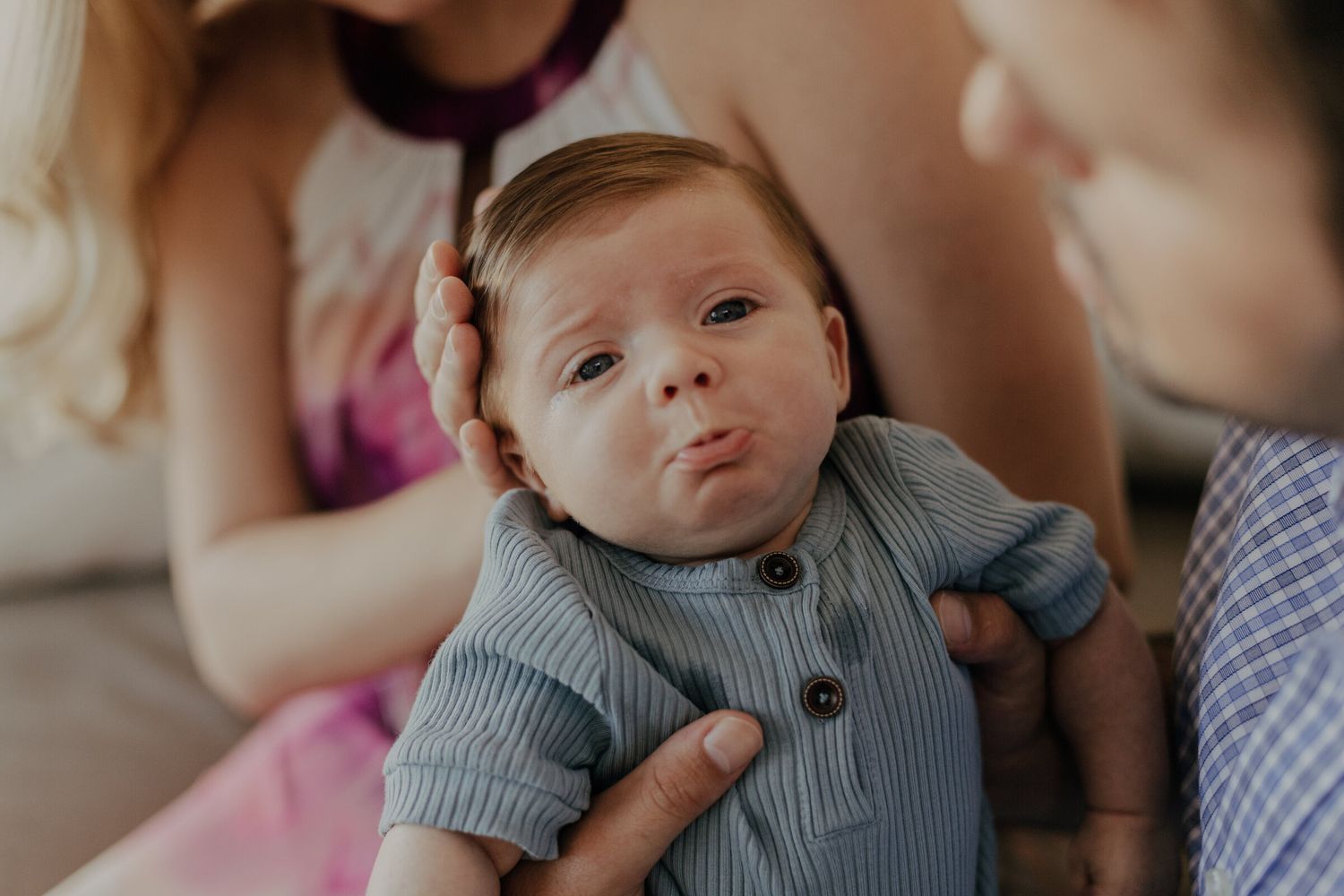 Baby wearing grey sweater during an intimate lifestyle photoshoot.
