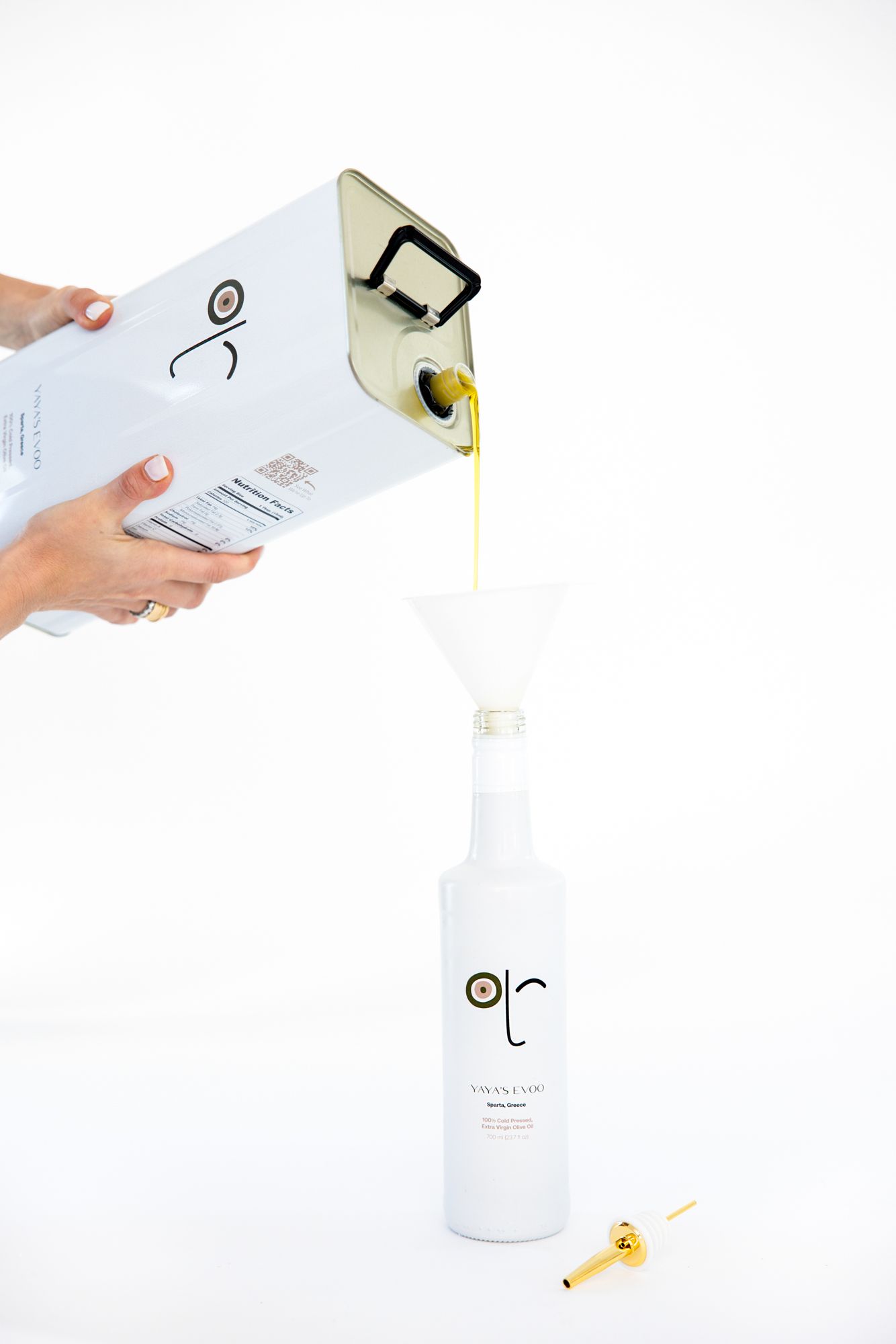 Person's hand holds and pours liquid from a modern white minimalist cosmetic or skincare product bottle.