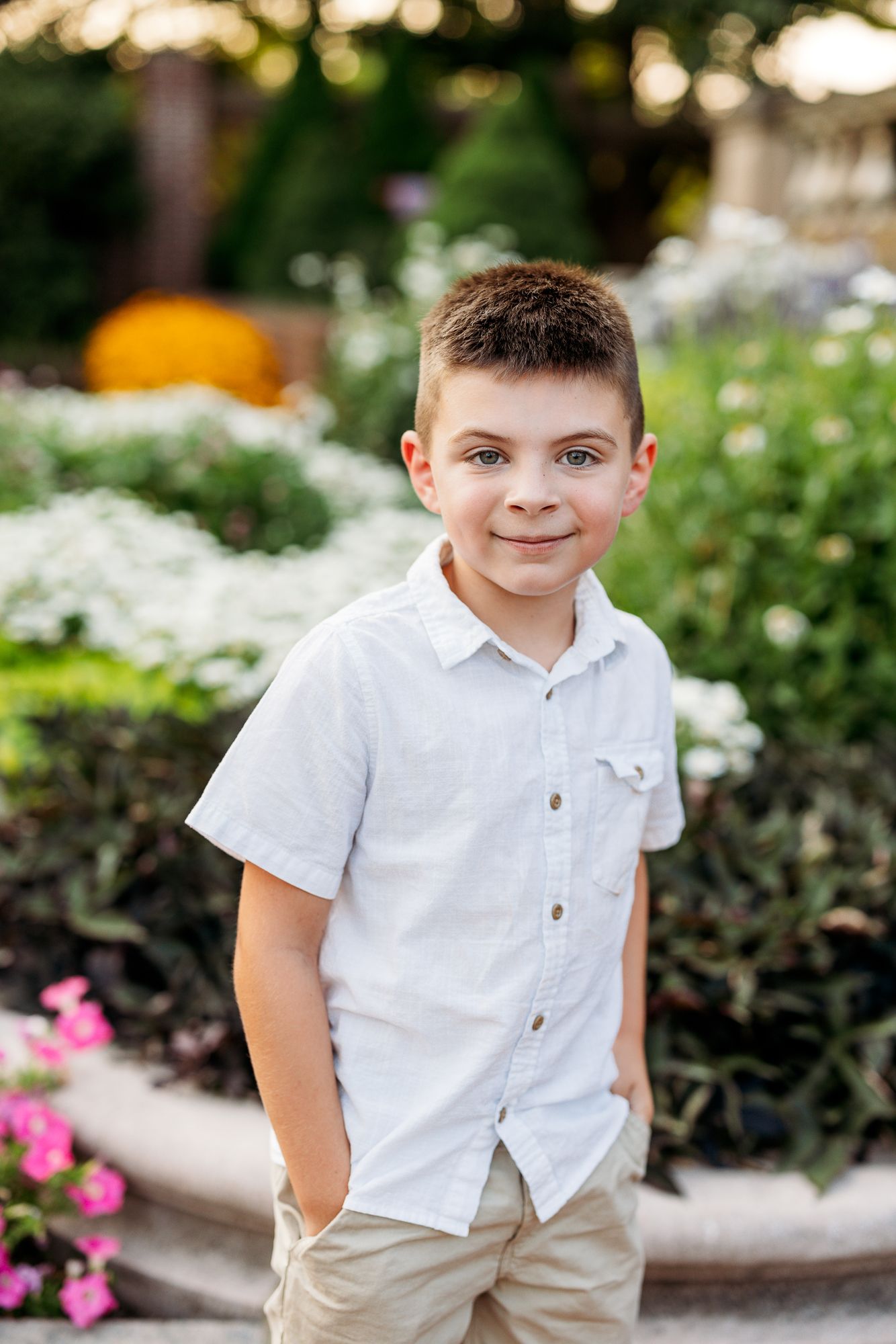 A series of outdoor portrait photos showing a young child in a white polo shirt and khaki shorts among blooming flowers.