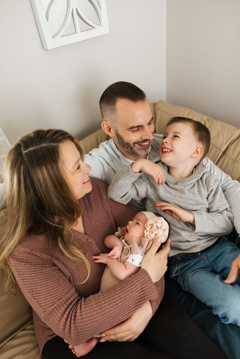 A joyful family moment shared on a beige couch in a cozy living room setting.