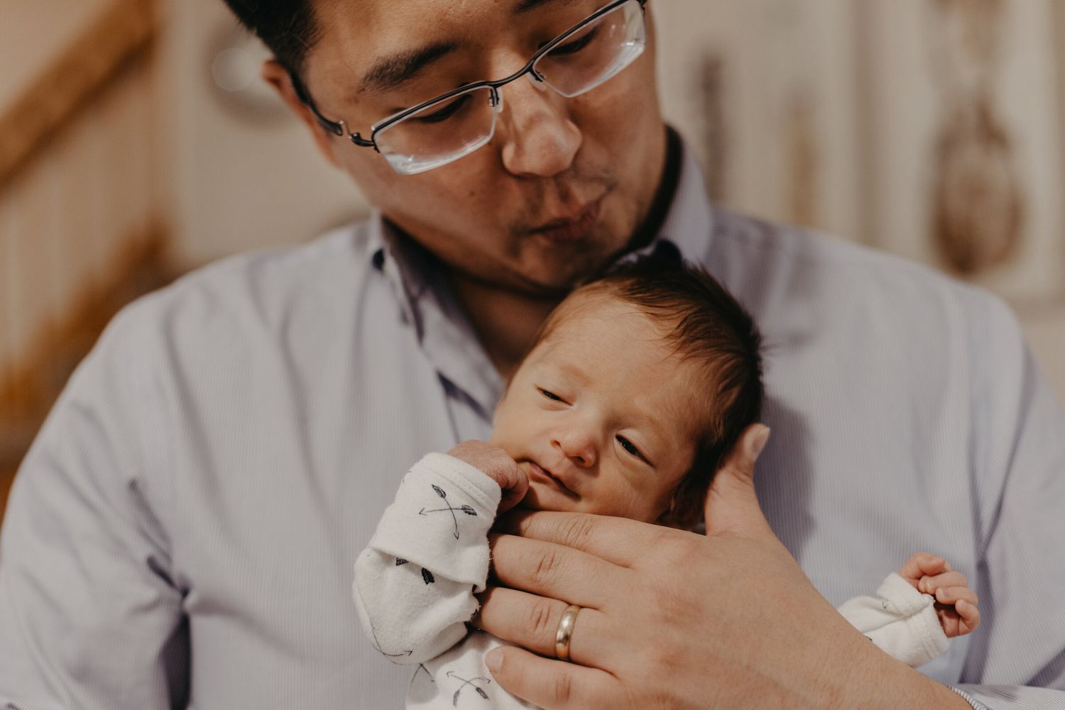 Tender moments between parent and newborn in soft natural light.