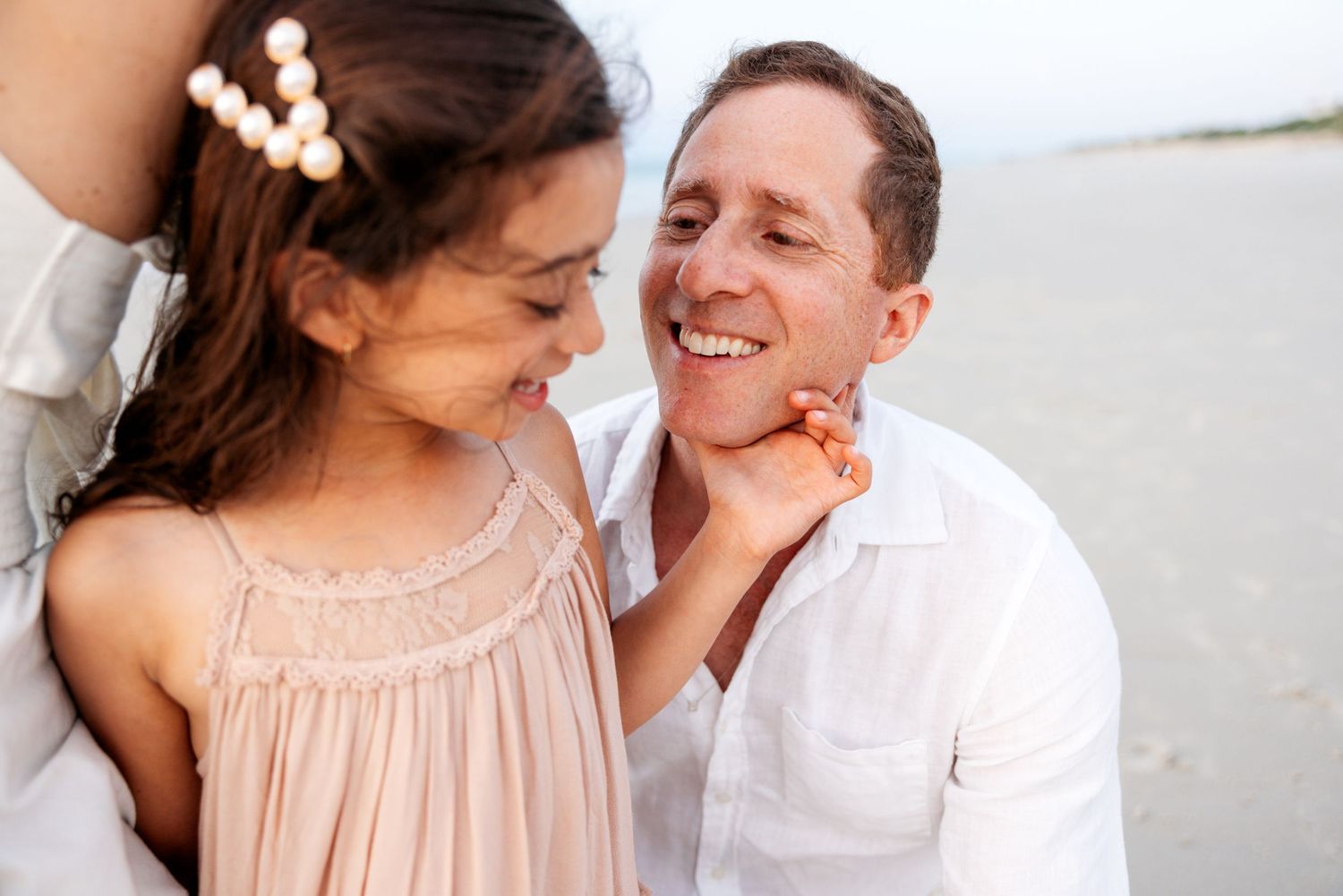Romantic couple sharing intimate moments in a bright dreamy setting wearing light colored clothing.