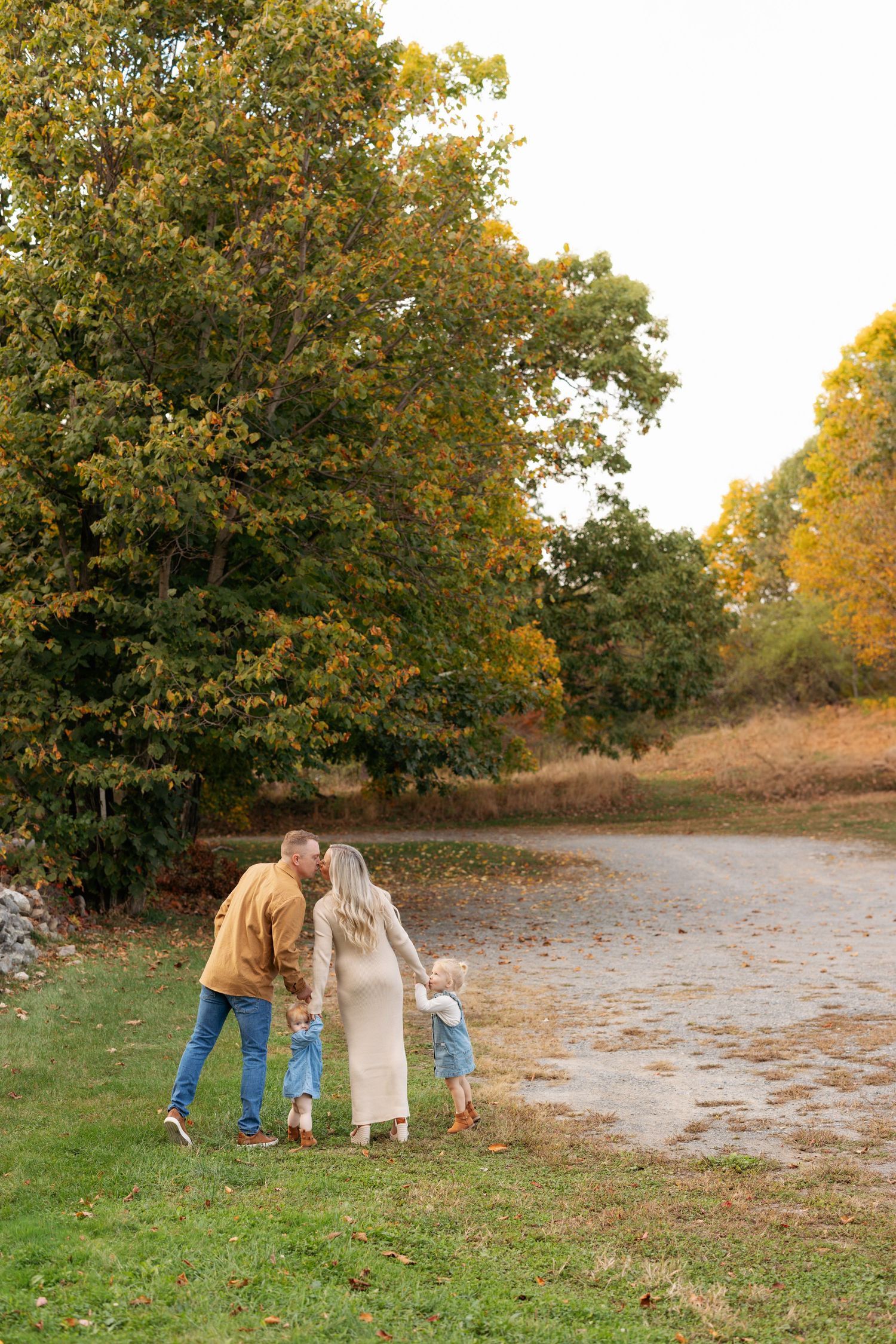 A sequence of playful autumn interactions captured in a grassy outdoor setting at sunset.