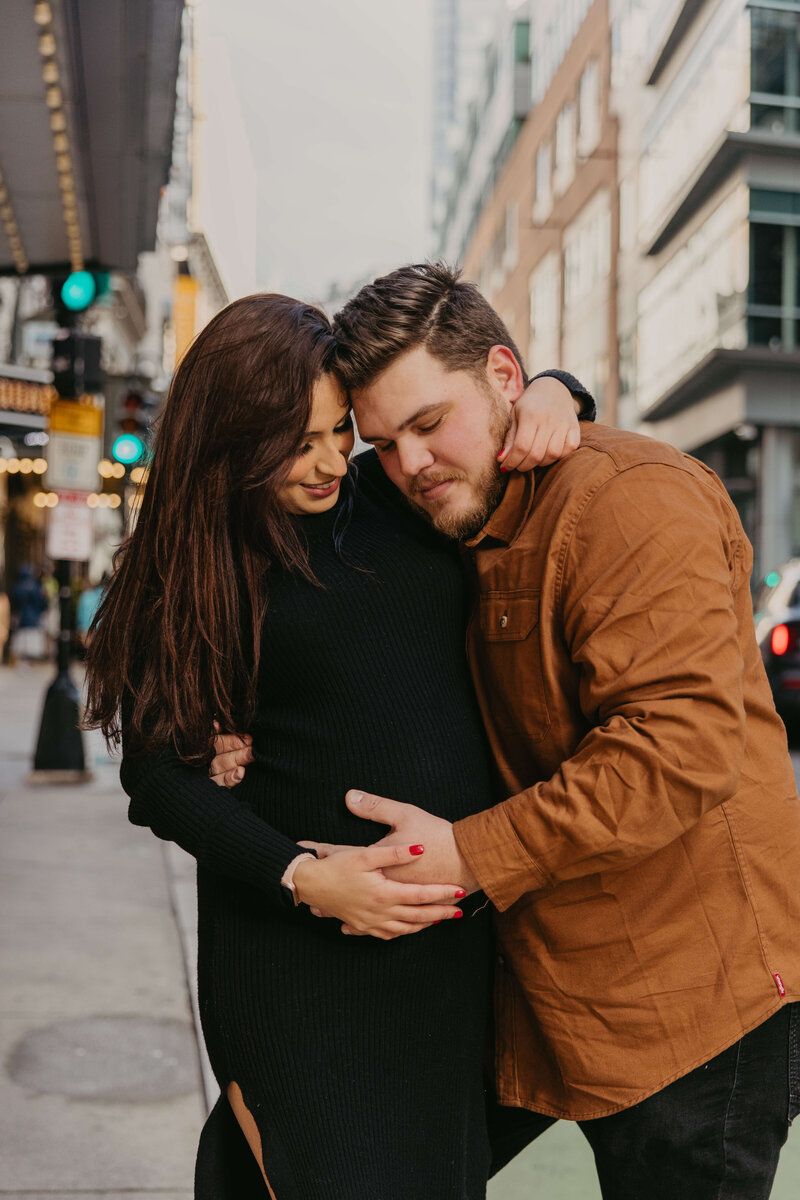 Intimate couple embracing in casual attire on city street.