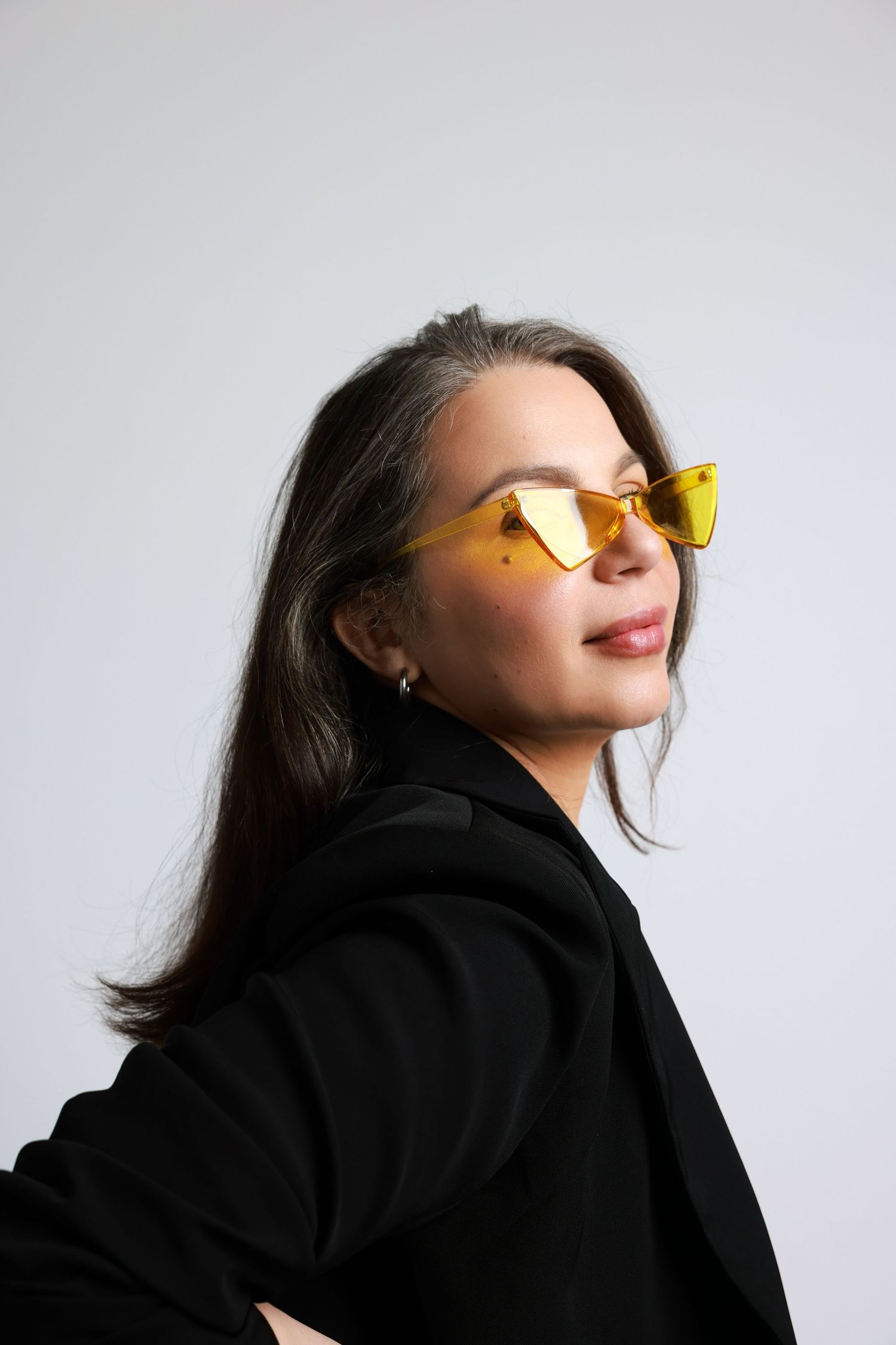 Portrait series showing yellow sunglasses with black sweater against white background.