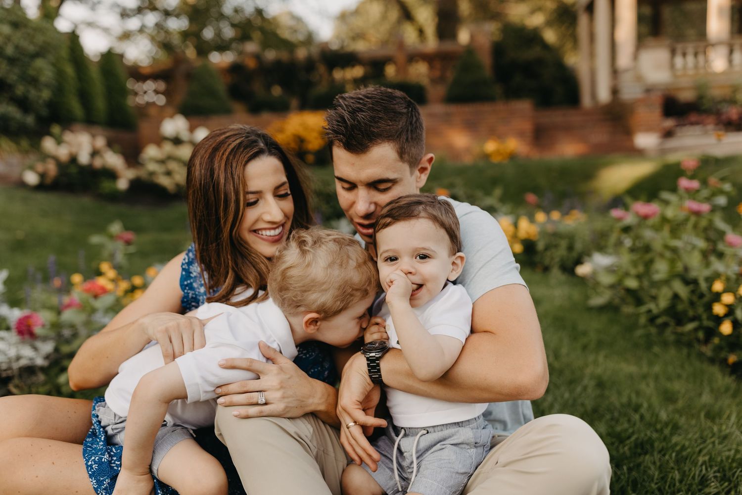Candid family moment shared on a green lawn during golden hour.