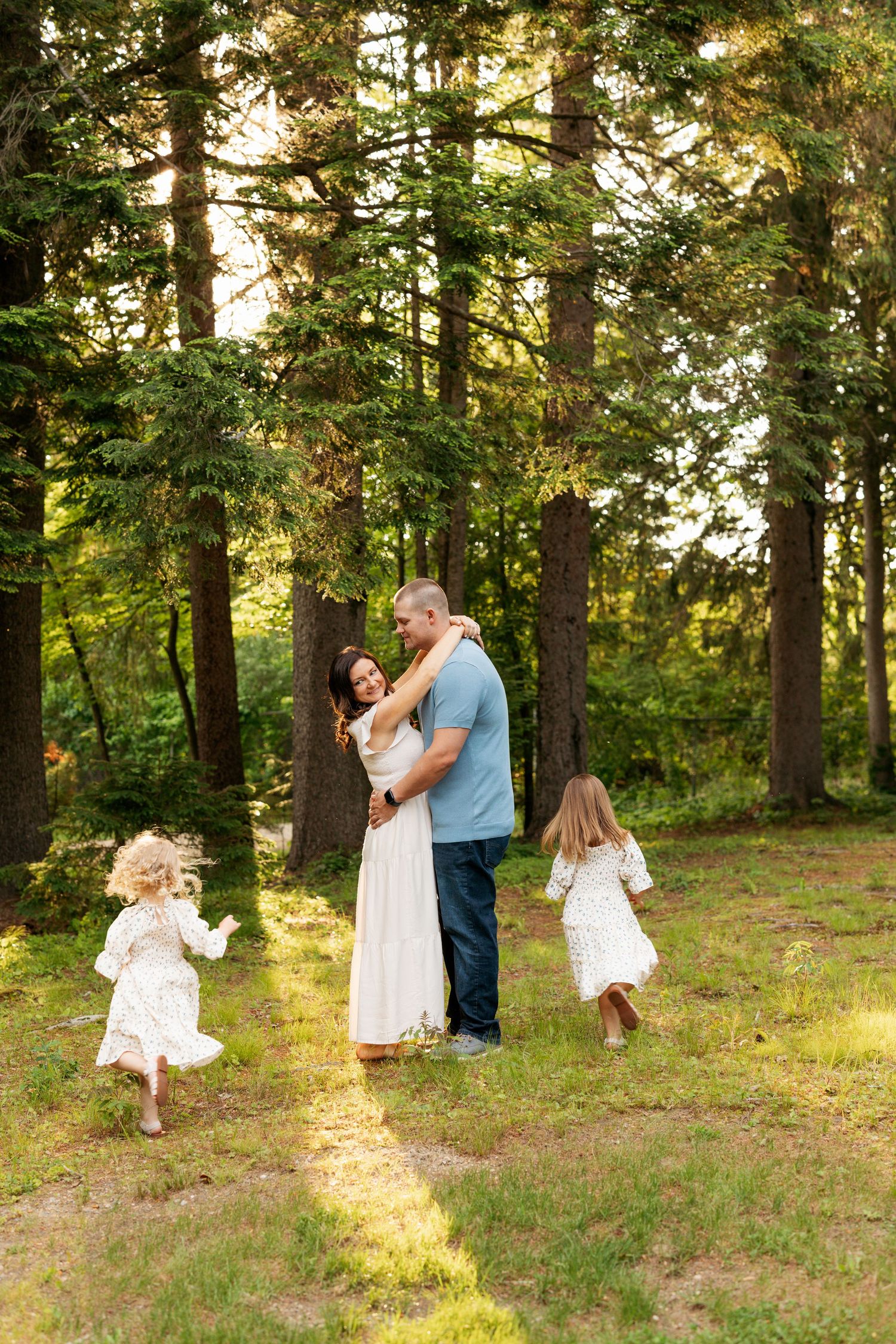 Dancing and twirling couples create romantic moments in a sunlit wooded area during golden hour.