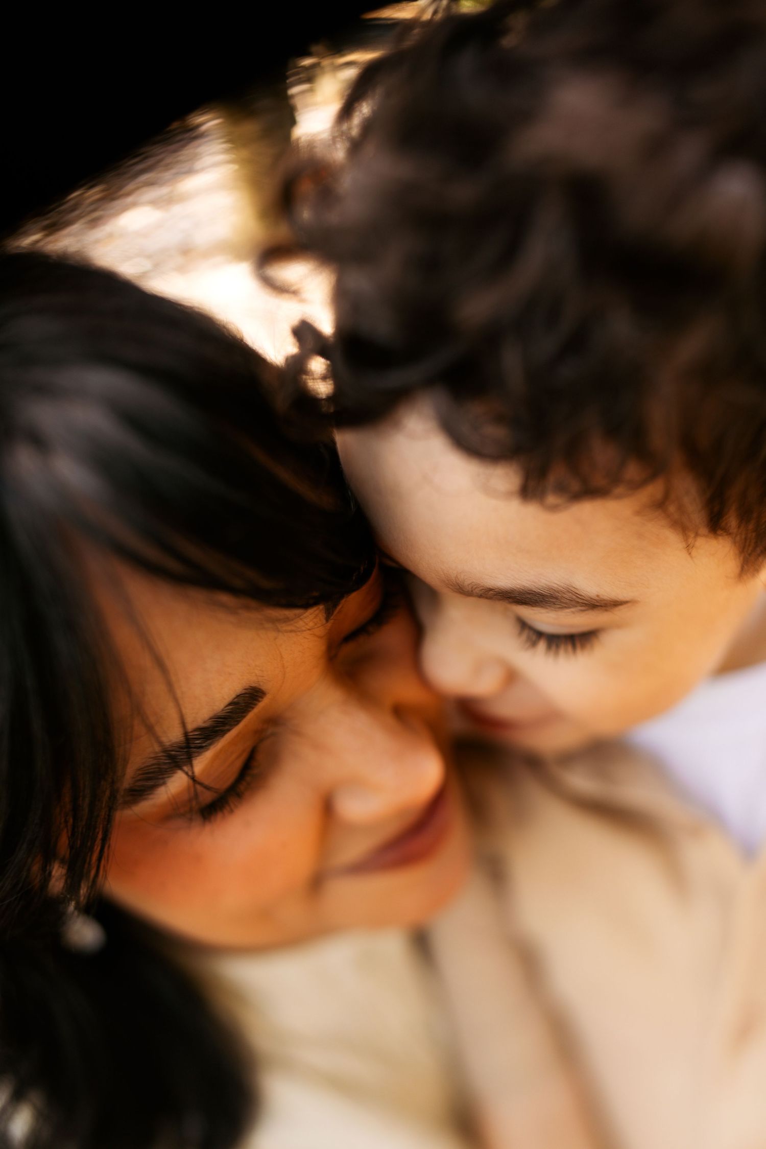 Close-up portraits in warm lighting showing intimate moments between two people with dark hair.
