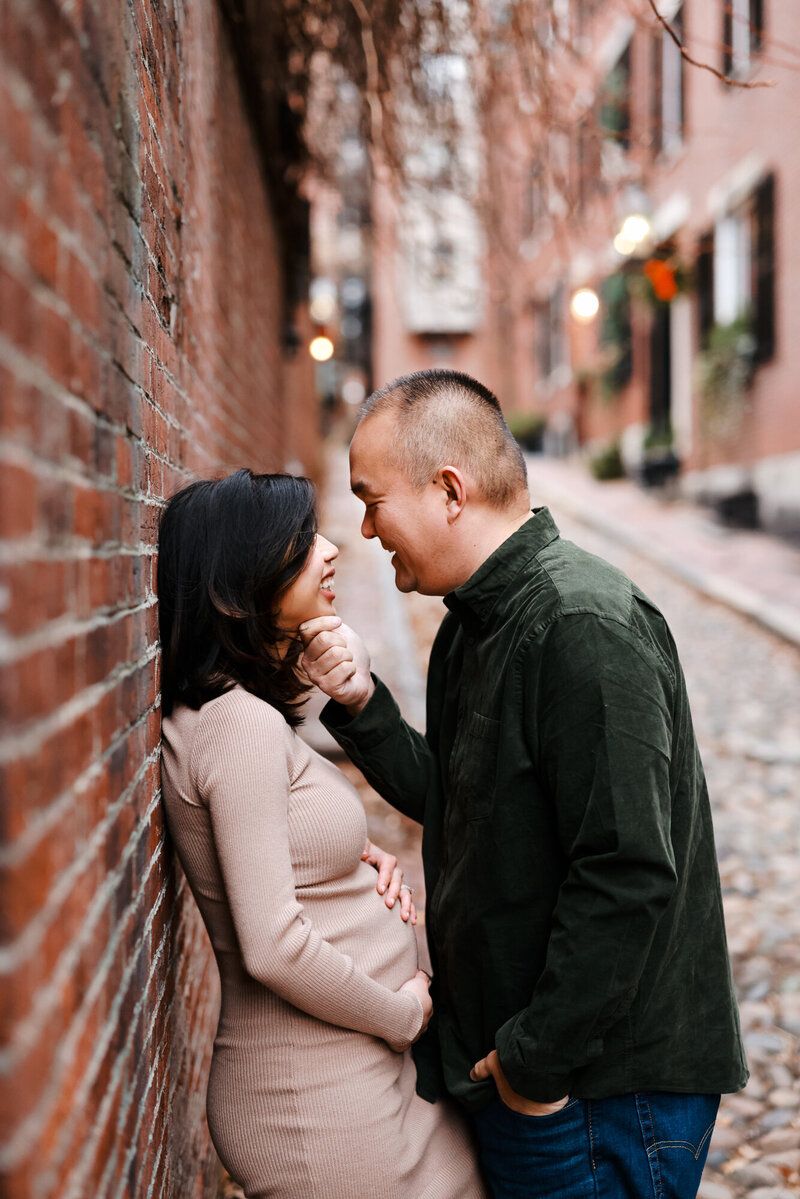 Romantic couple portraits against rustic brick walls in an urban setting.