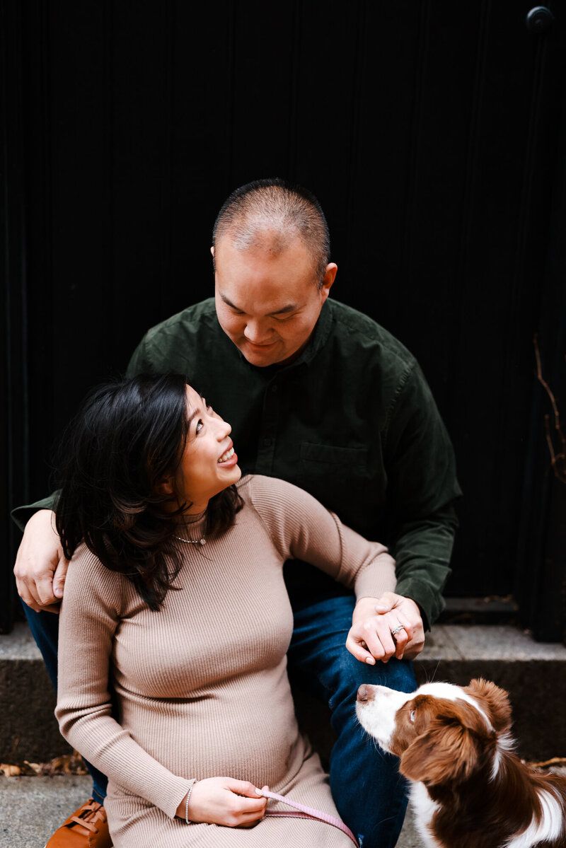 Intimate lifestyle photography session with a couple and their dog on stone steps.