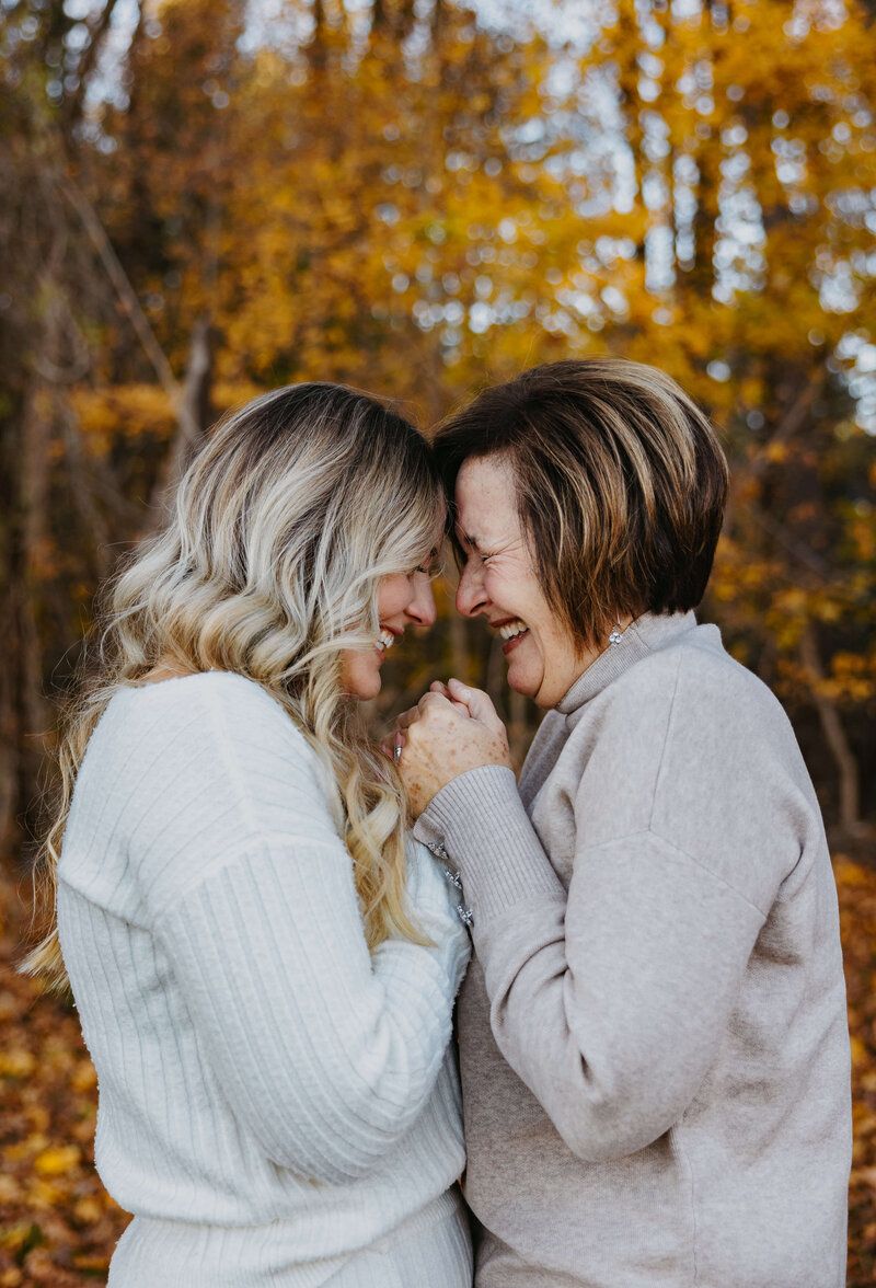 Couple sharing intimate moment surrounded by golden autumn foliage.
