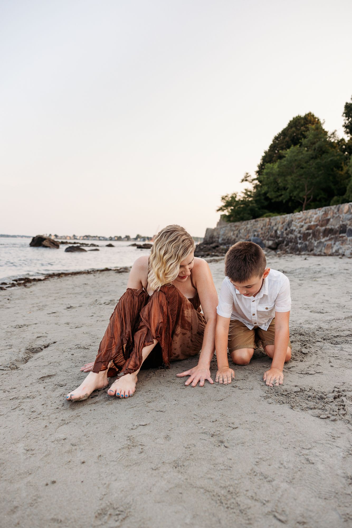 Two people lying on sandy beach at sunset creating artistic low angle composition.