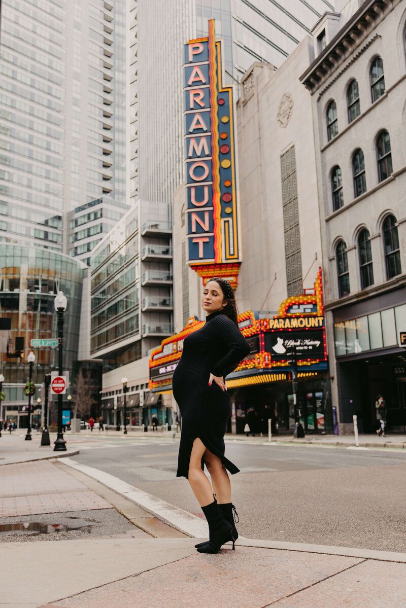 Urban photo shoot in front of vintage theater marquee signs in downtown city setting.