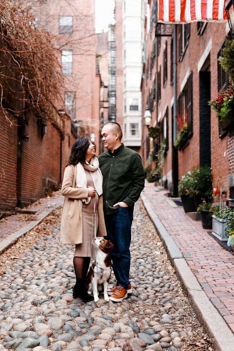 Romantic autumn photo session on a historic cobblestone street lined with brick buildings and fall foliage.