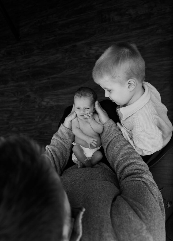 A tender moment captured in black and white as an infant and parent share a close embrace.