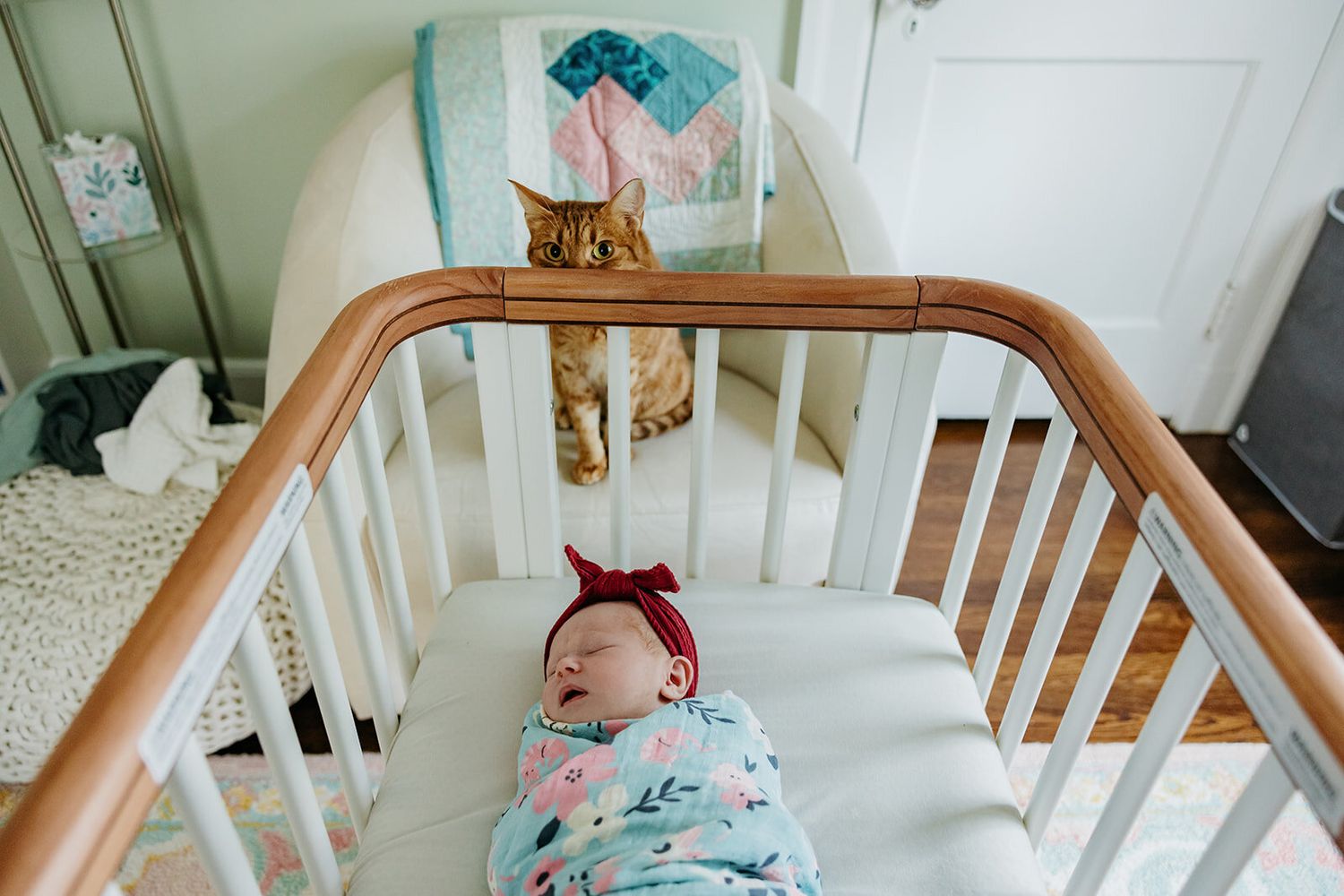Sweet newborn baby sleeps peacefully in a white wooden crib.