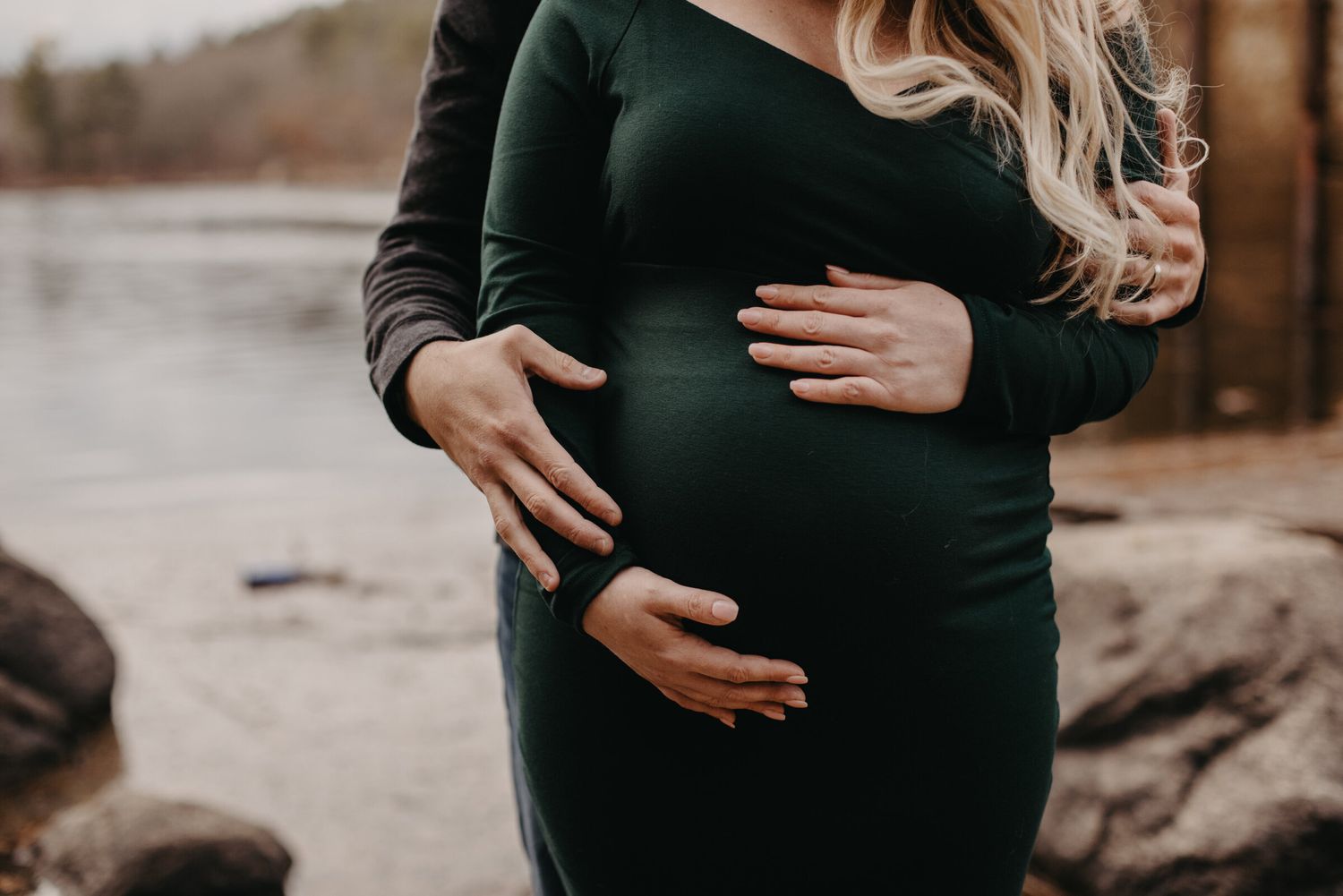 Artistic maternity portraits captured against a serene lakeside setting.