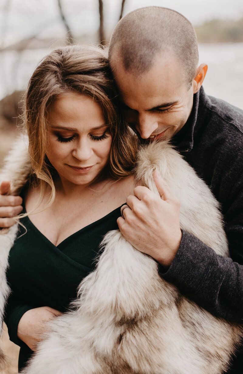 Cozy winter maternity photos featuring warm fur wraps and intimate poses.