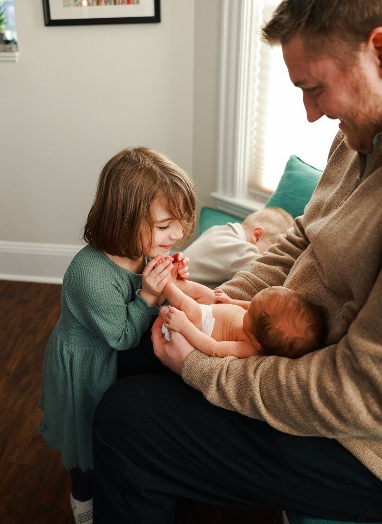 Family members share a tender moment of bonding and affection while sitting together on a couch at home.