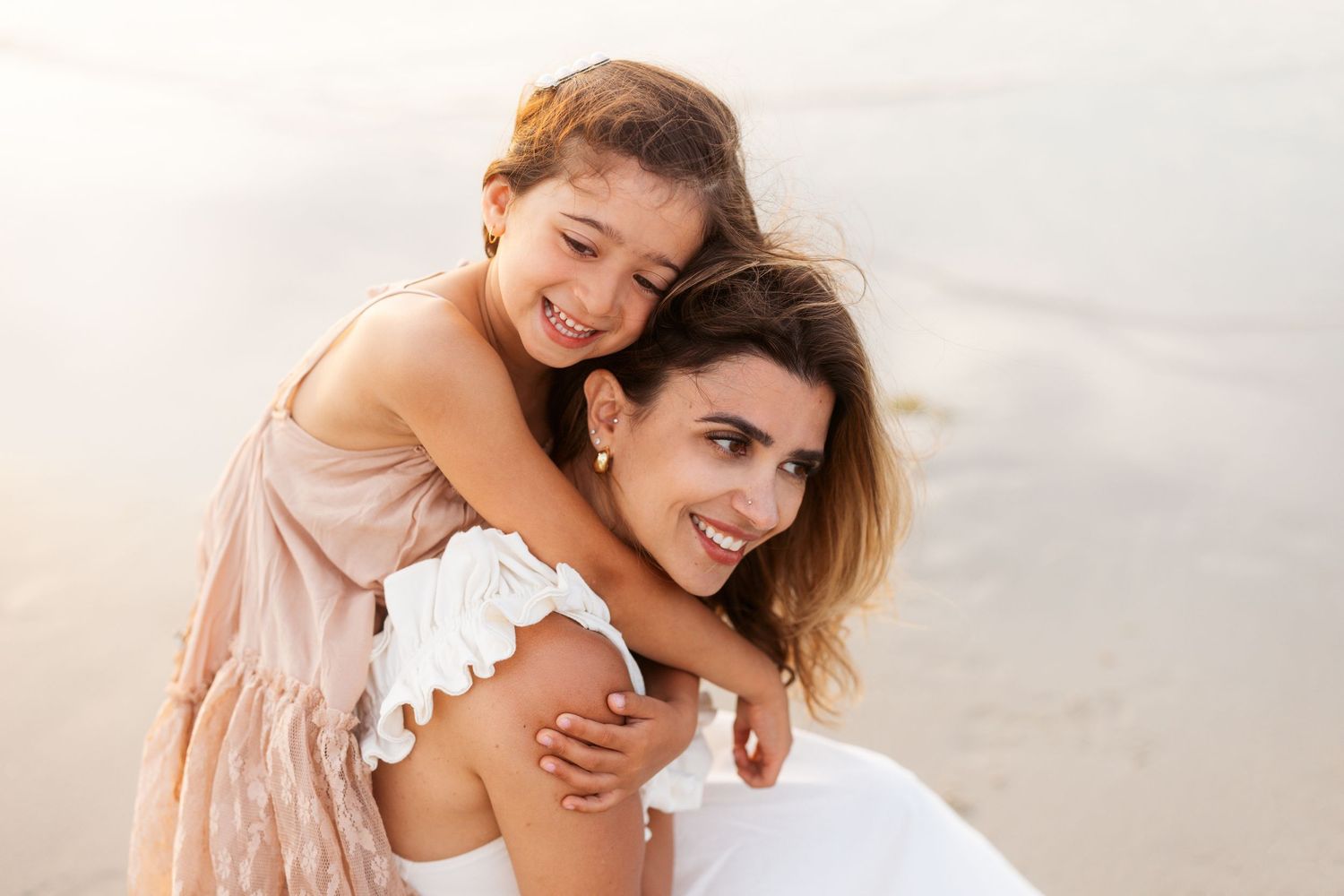 Paradise family portraits show loving moments on white sandy beach in soft pastel tones and flowy dresses.